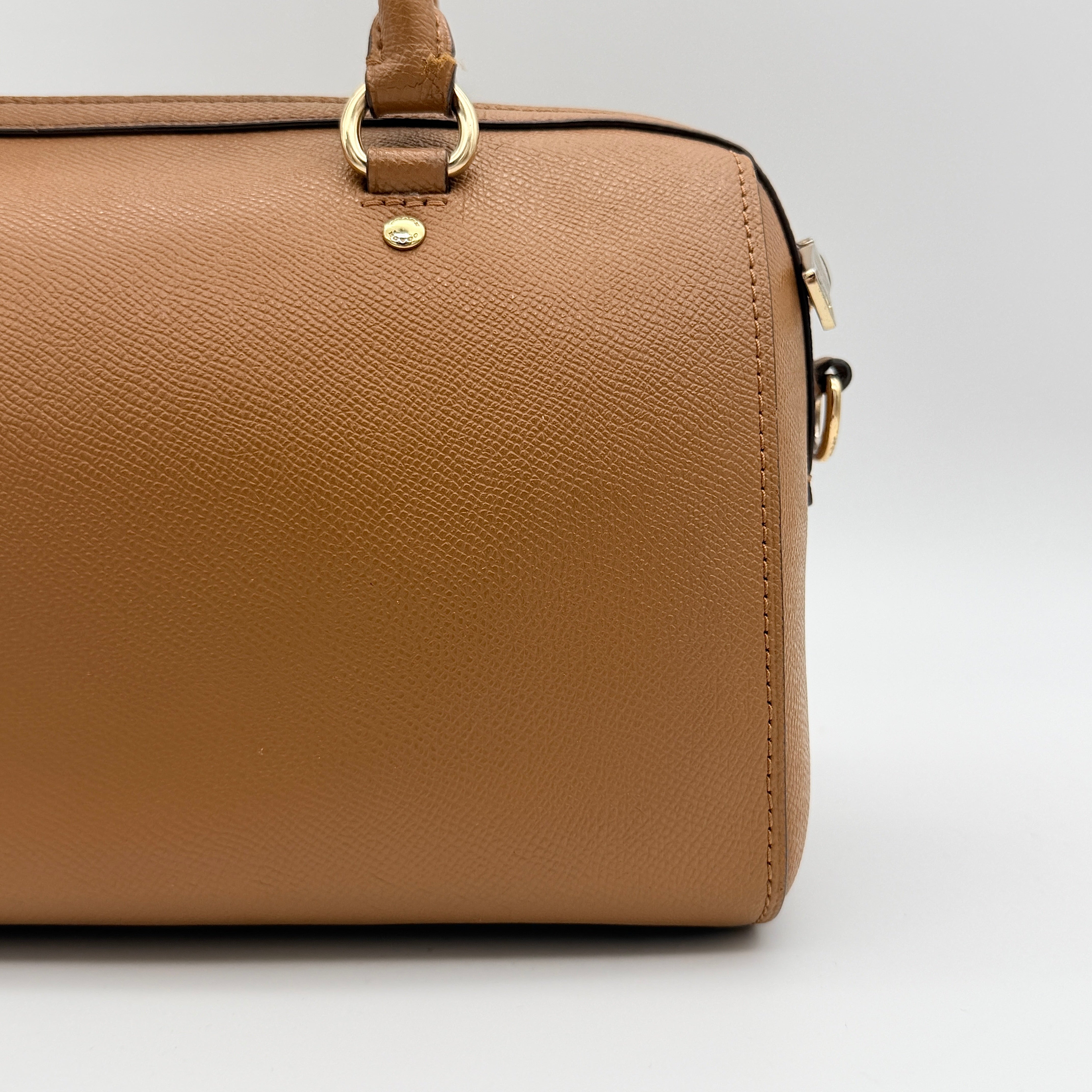 Coach Rowan satchel in brown grained leather with gold hardware, shown with dust bag, strap, and care cards.