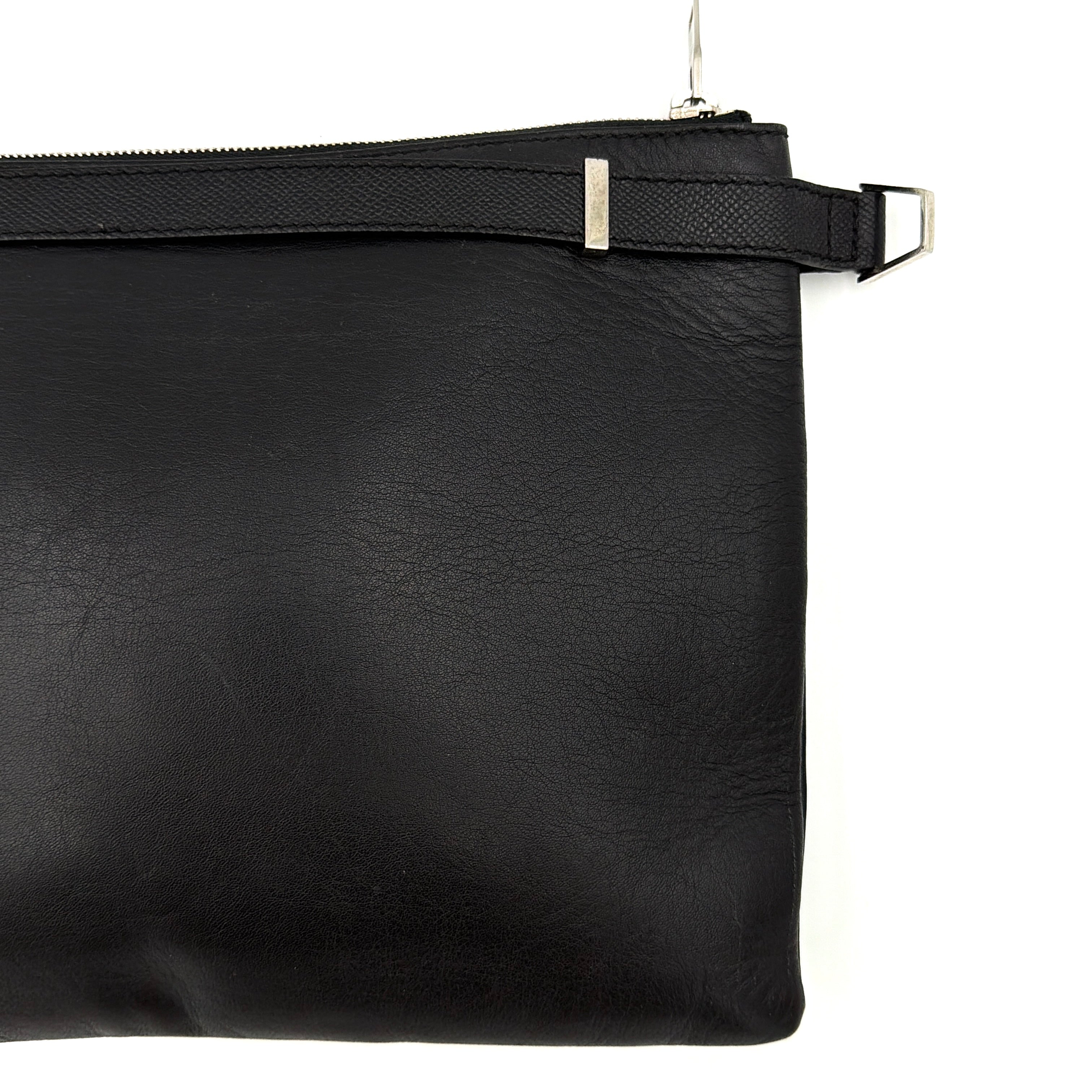 Balenciaga Phileas clutch in smooth black leather with silver hardware, shown against a white background.