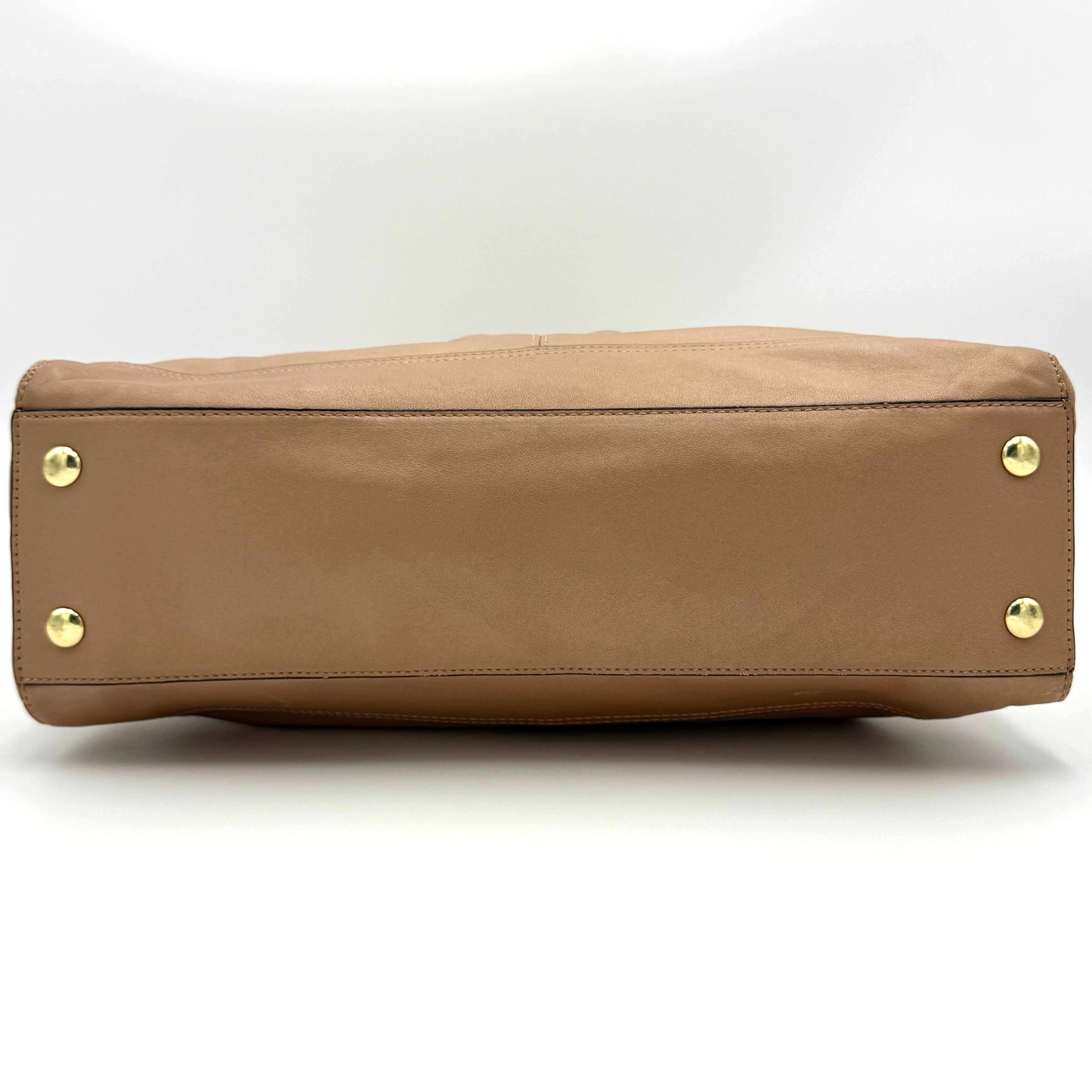 Coach Park Leather Carryall in beige leather with gold-tone hardware and double handles, styled with signature Coach hangtags.