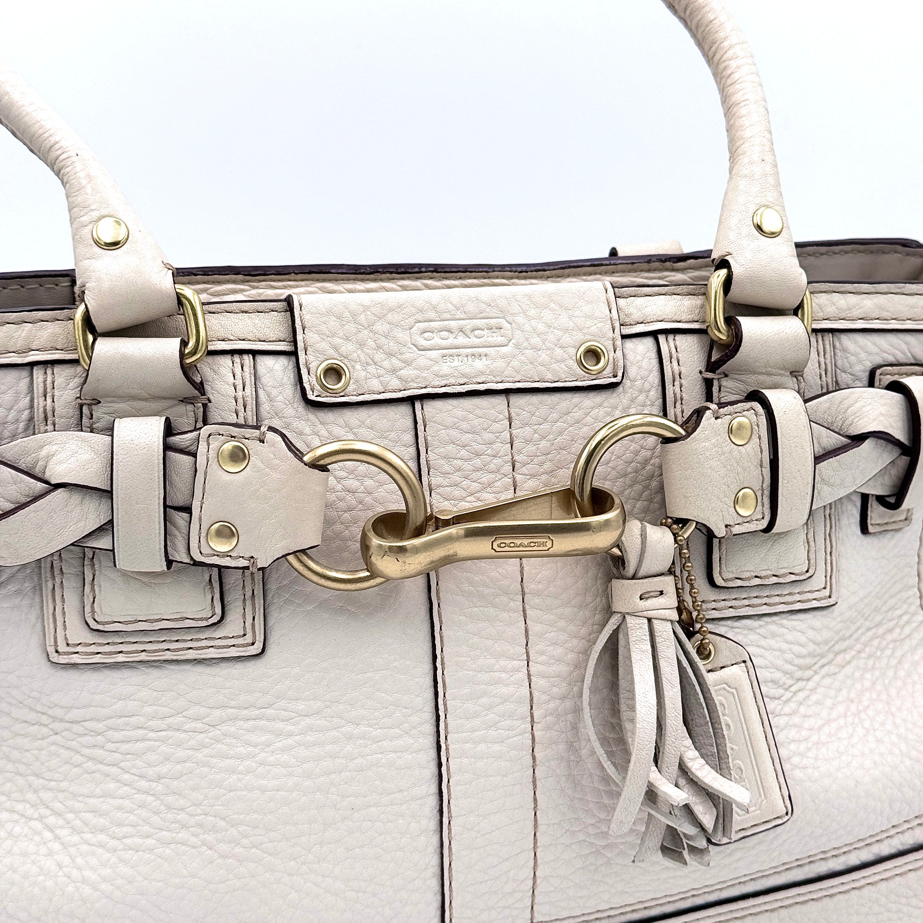 Coach Signature Hampton Carryall Shoulder Bag in ivory pebbled leather with gold-tone hardware and braided detailing, shown from the front.