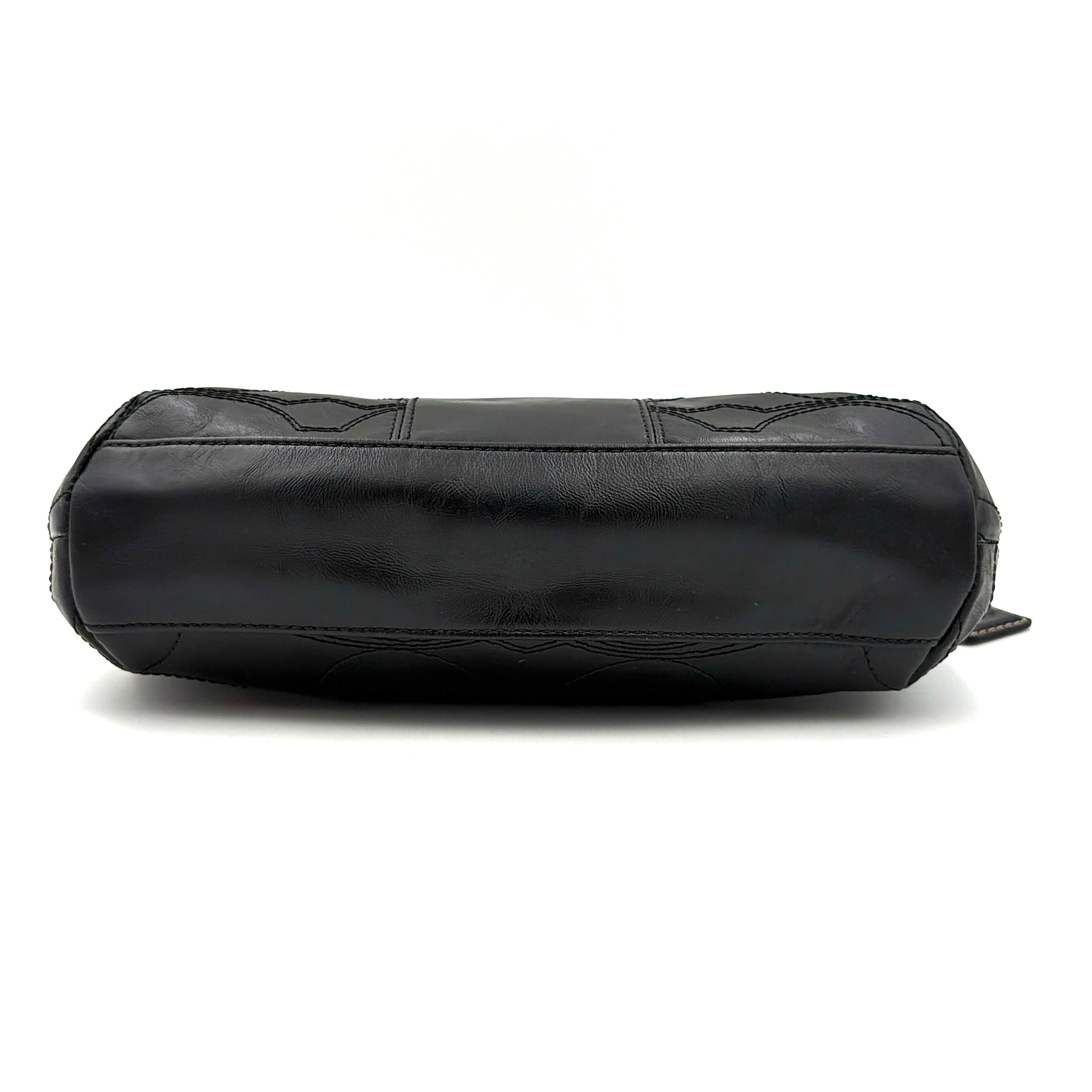 Coach black leather shoulder bag with signature embossed pattern and silver hardware, shown with attached logo tag and short leather strap.