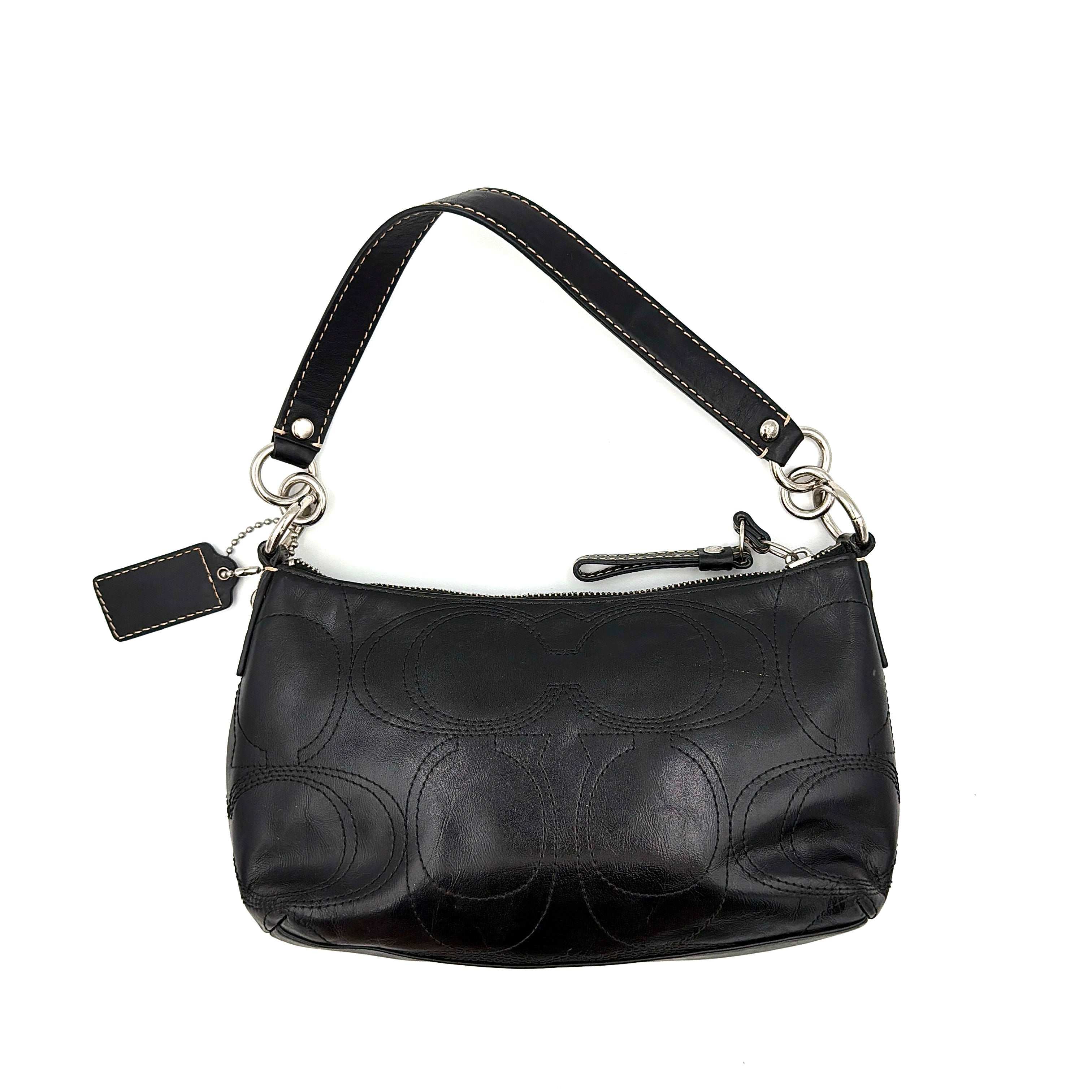 Coach black leather shoulder bag with signature embossed pattern and silver hardware, shown with attached logo tag and short leather strap.