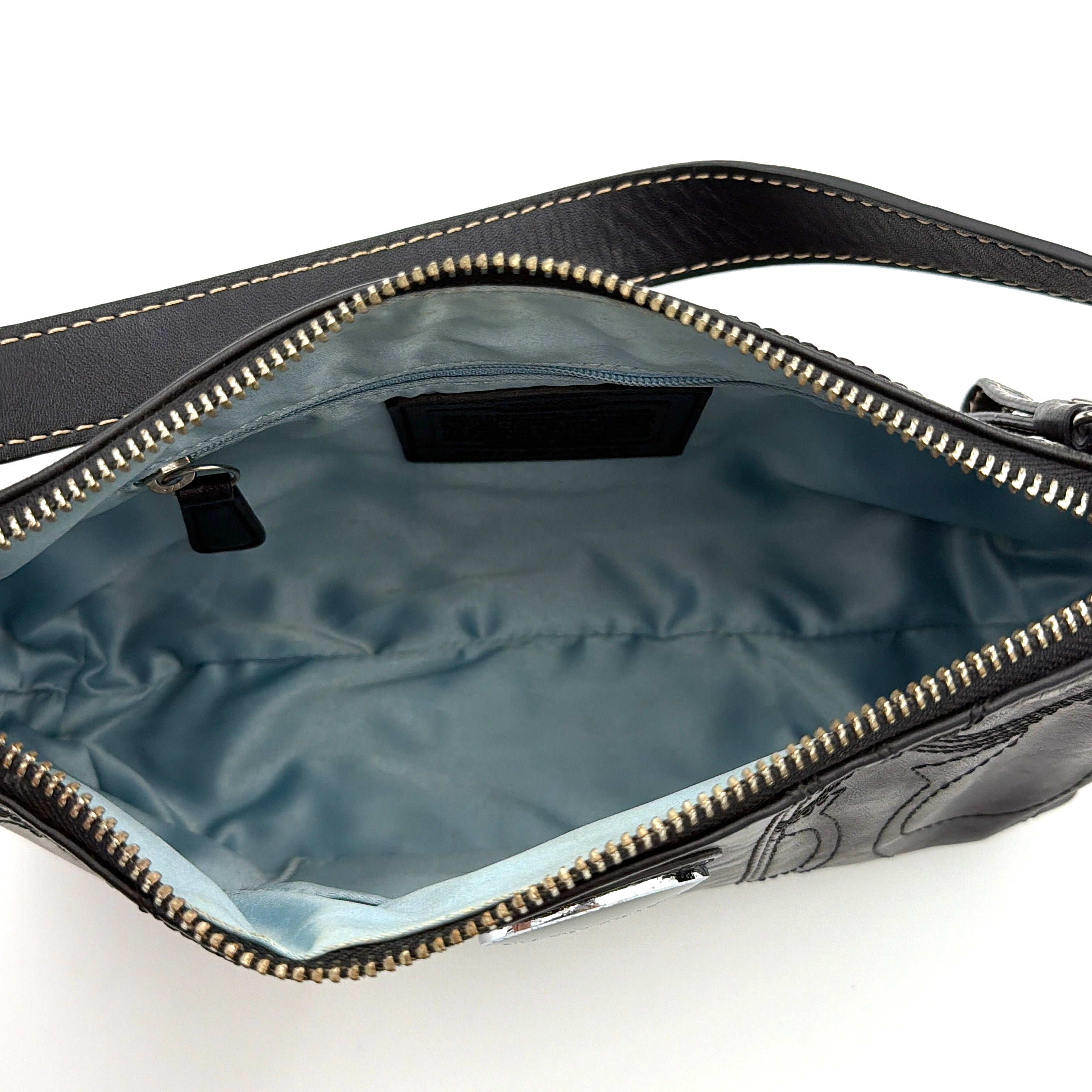 Coach black leather shoulder bag with signature embossed pattern and silver hardware, shown with attached logo tag and short leather strap.
