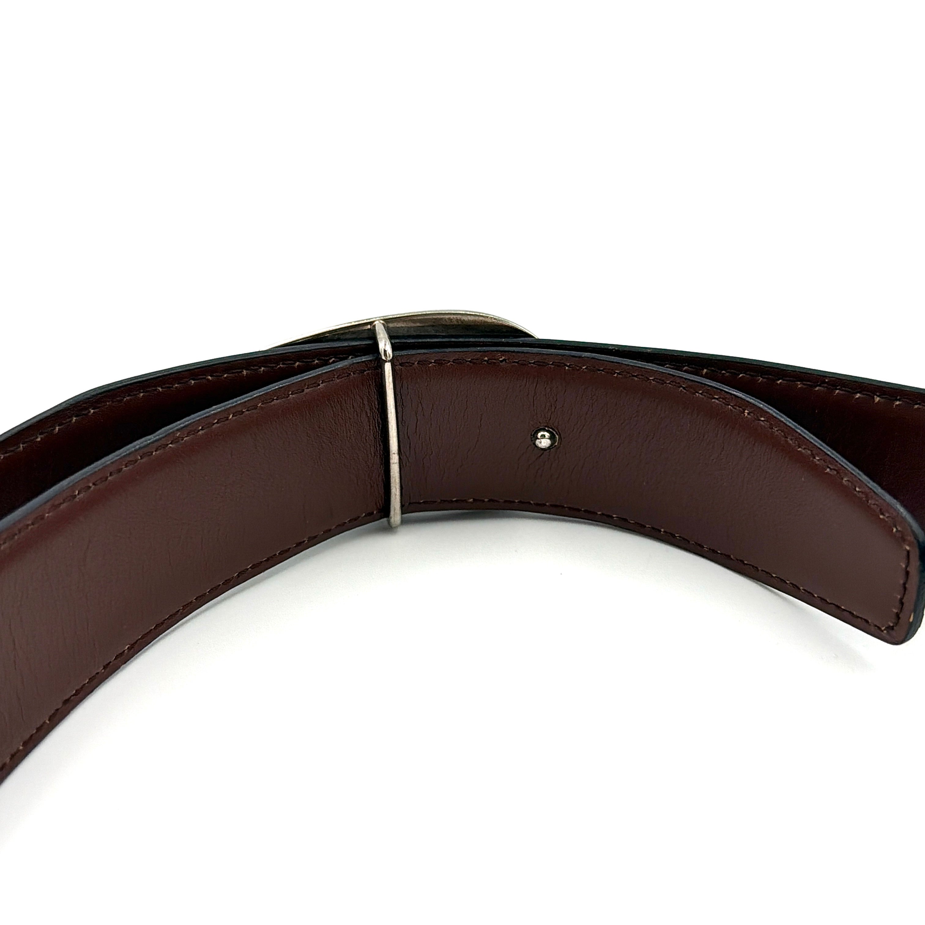 Gucci black leather belt with an oversized silver metal G logo buckle displayed in a curved profile.