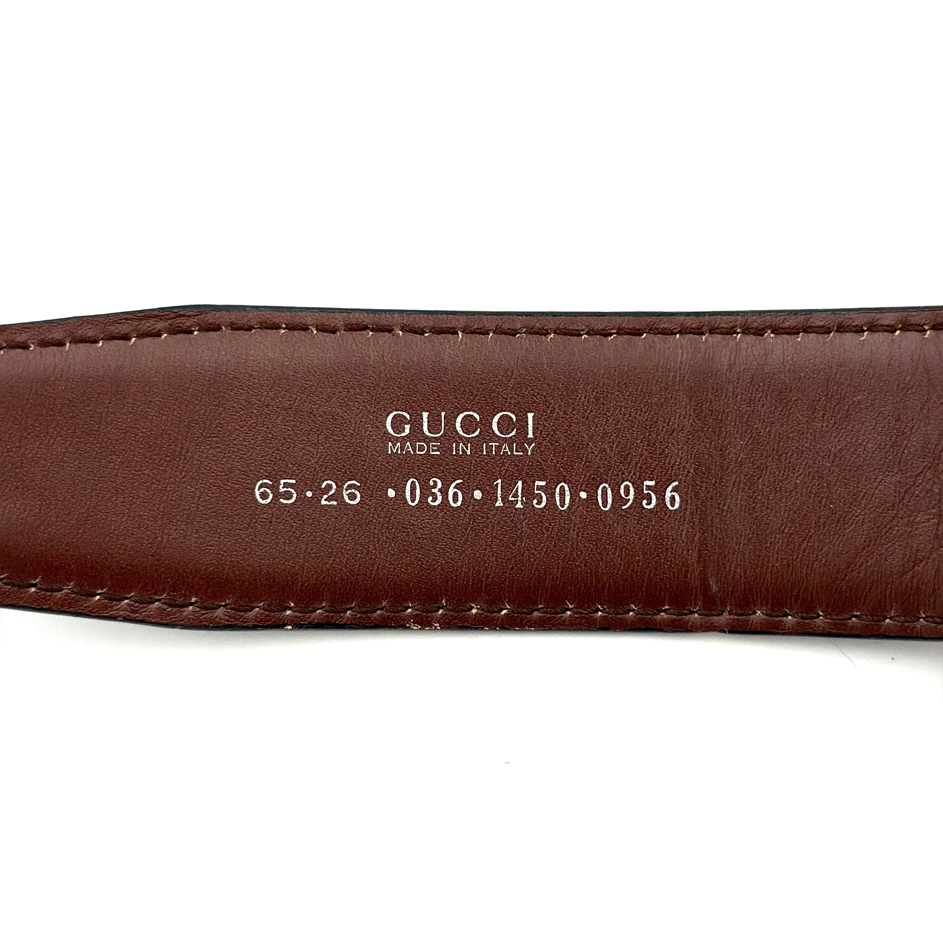 Gucci black leather belt with an oversized silver metal G logo buckle displayed in a curved profile.