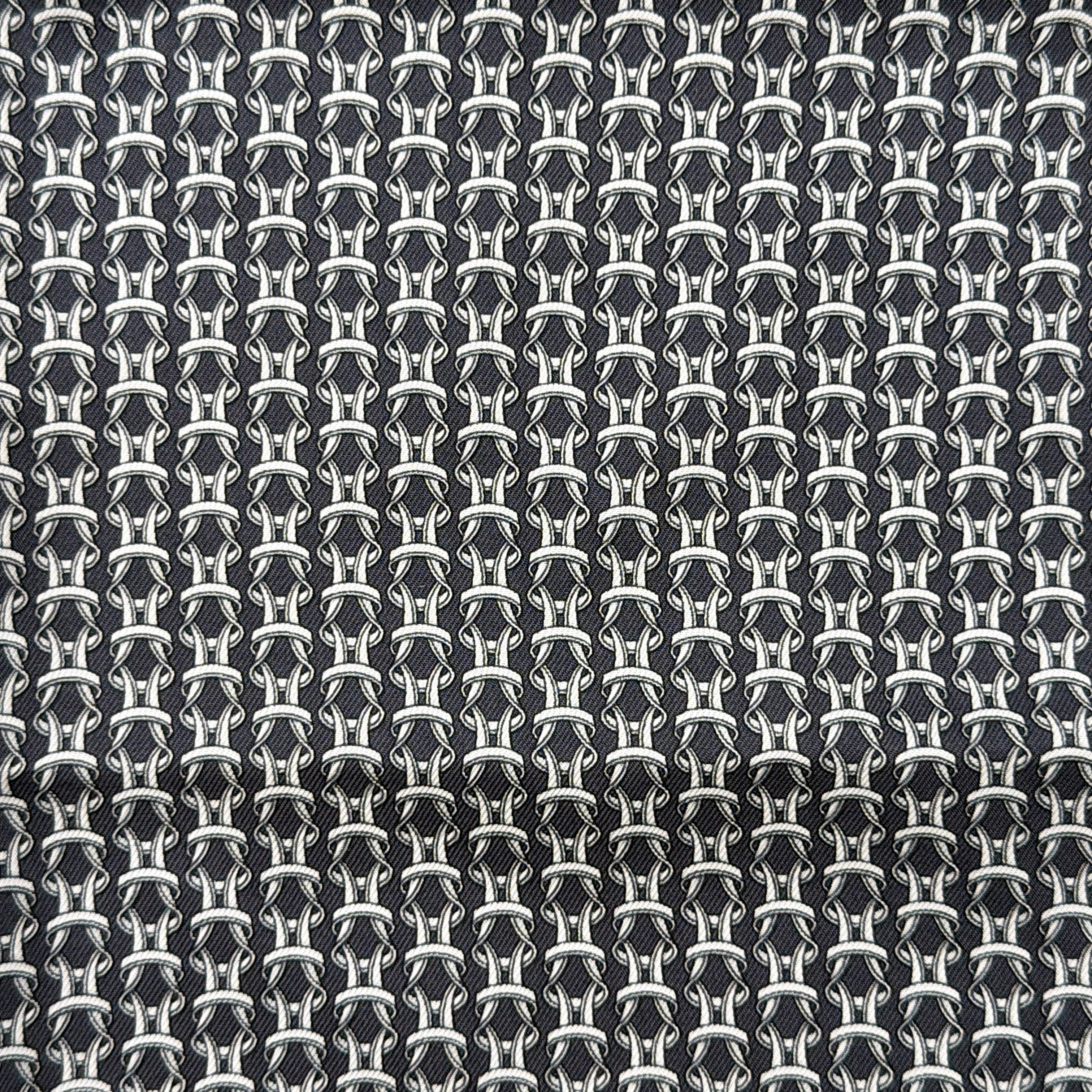 Hermès silk scarf in navy blue with a white chain link pattern and bold border, elegantly displayed flat.