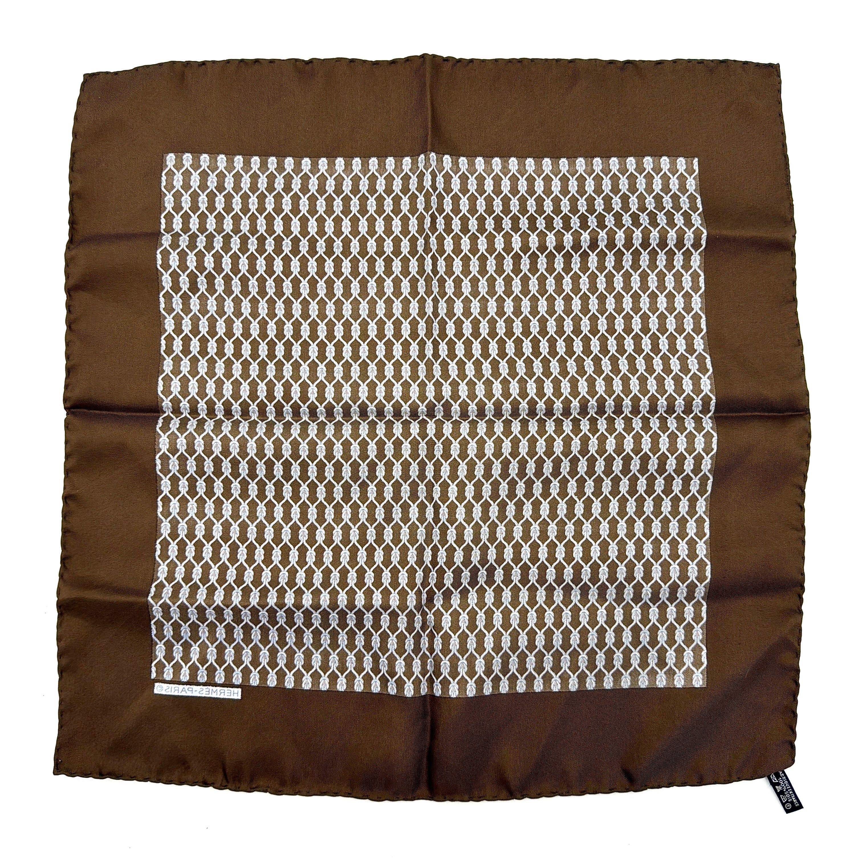 Hermès brown silk scarf featuring a blue and white chain link pattern, finished with elegant rolled edges.