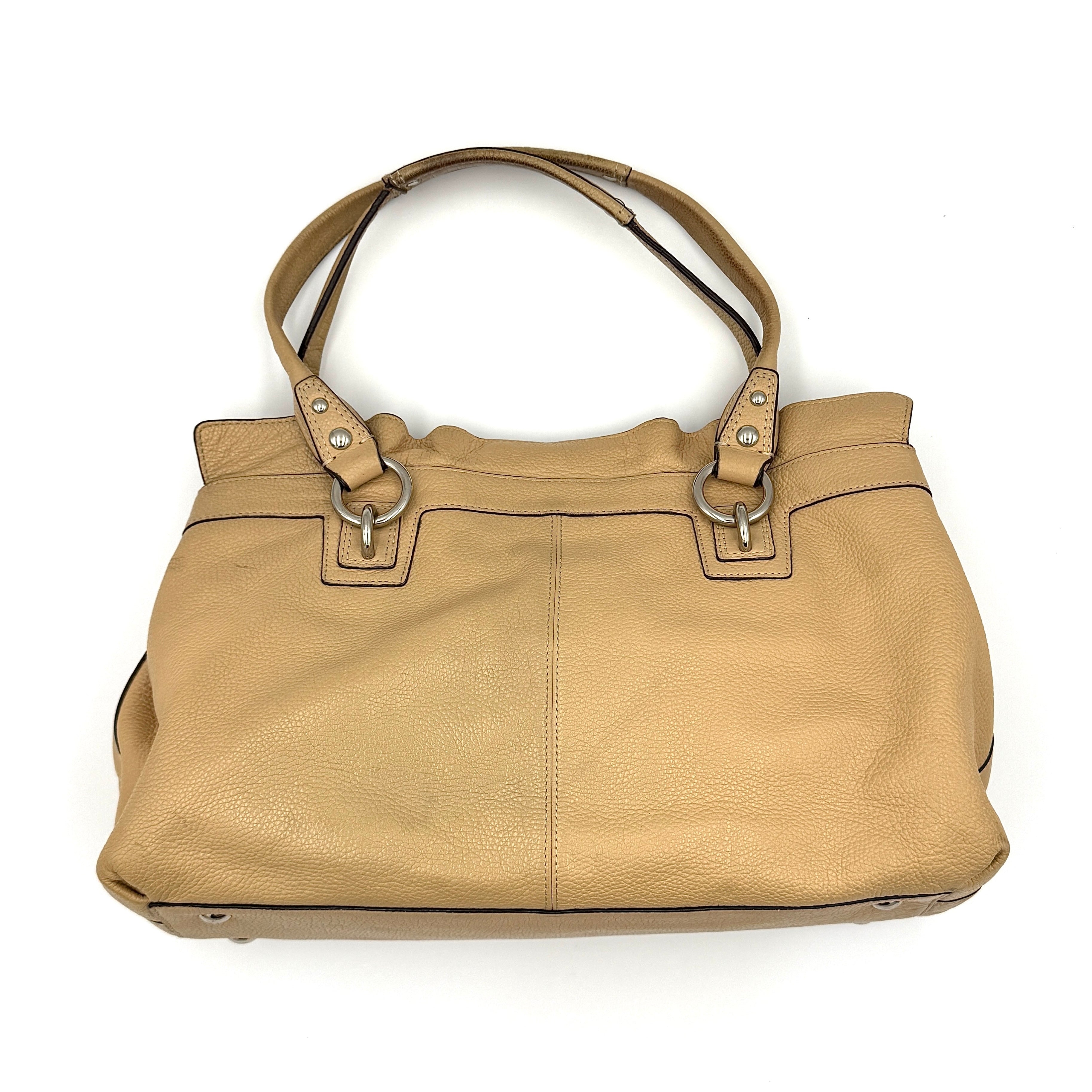 Coach Penelope handbag in cream pebble leather with rolled handles and silver-tone hardware against a white background.