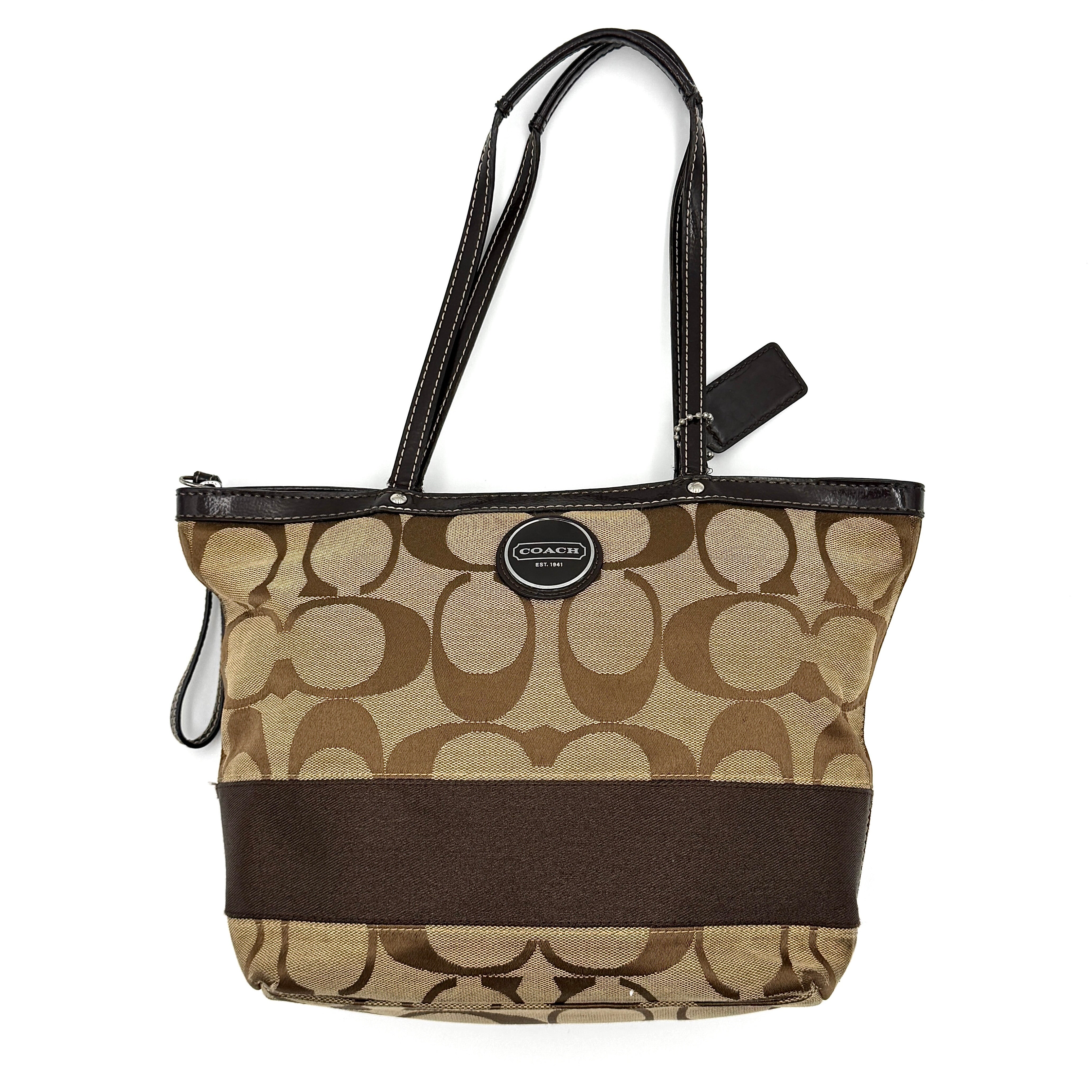 Coach Signature Stripe Tote Bag in beige and brown with bold monogram canvas, leather trim, and dual shoulder straps.