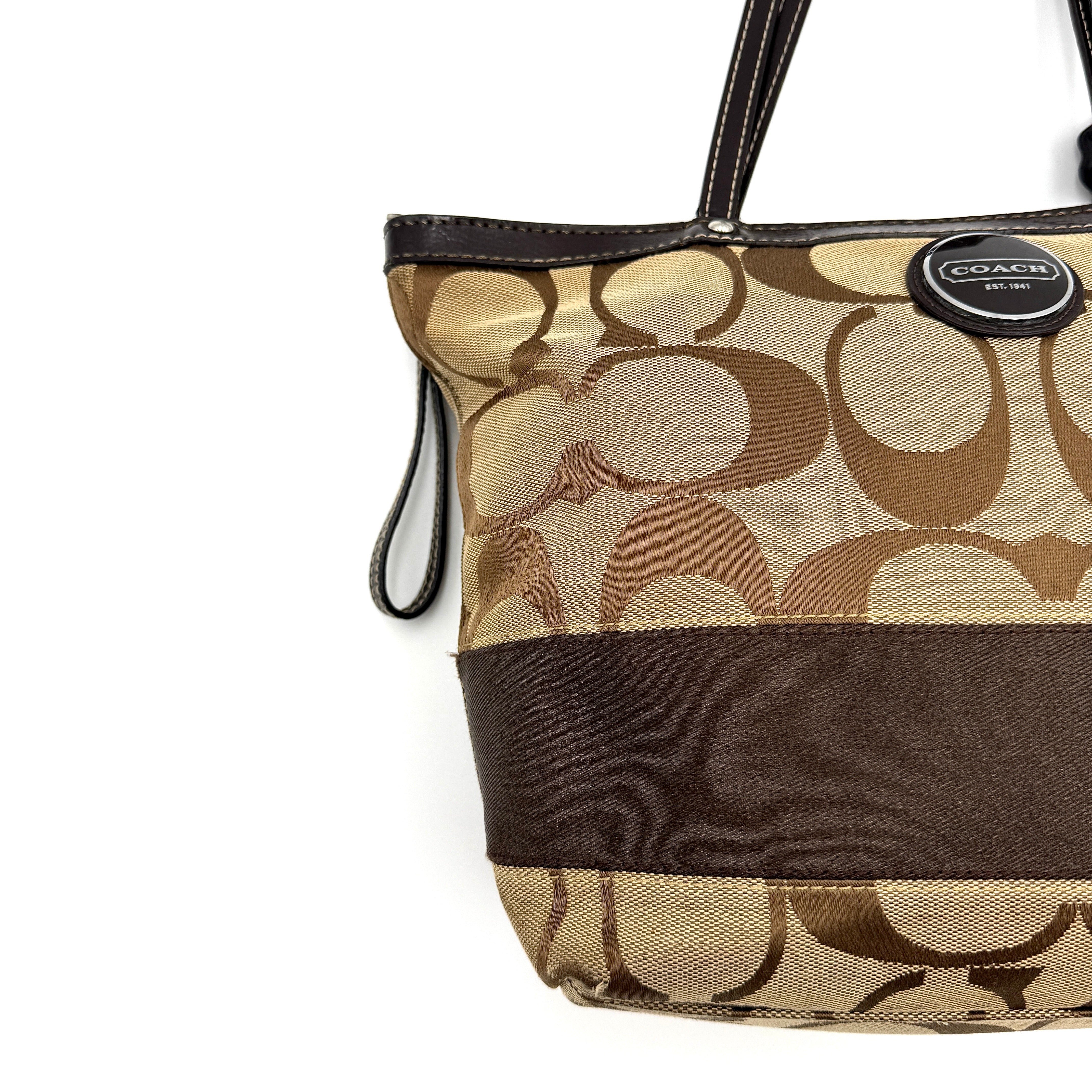 Coach Signature Stripe Tote Bag in beige and brown with bold monogram canvas, leather trim, and dual shoulder straps.