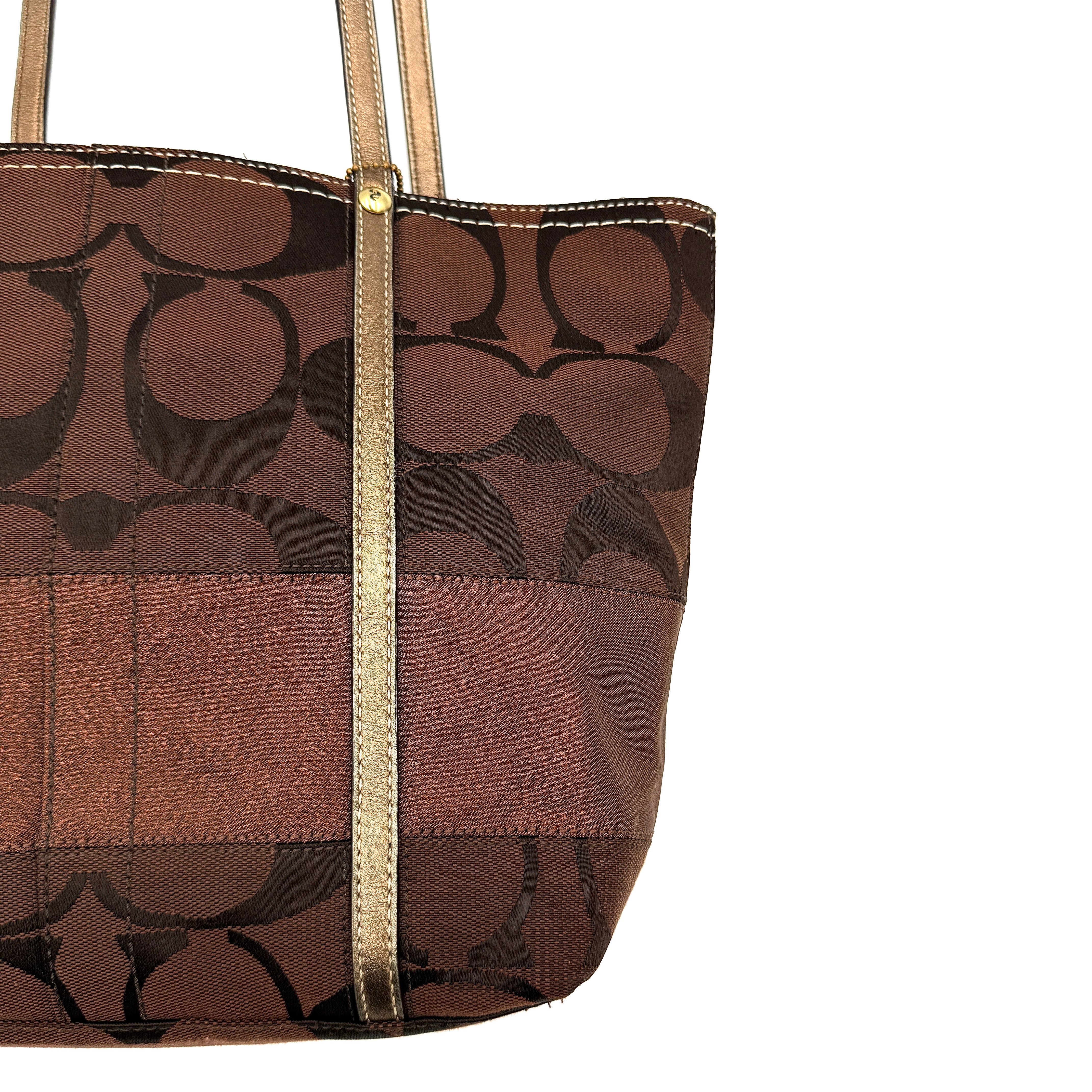 Coach Signature Stripe Tote Bag in rich brown monogram canvas with metallic gold leather handles, photographed upright against a clean background.