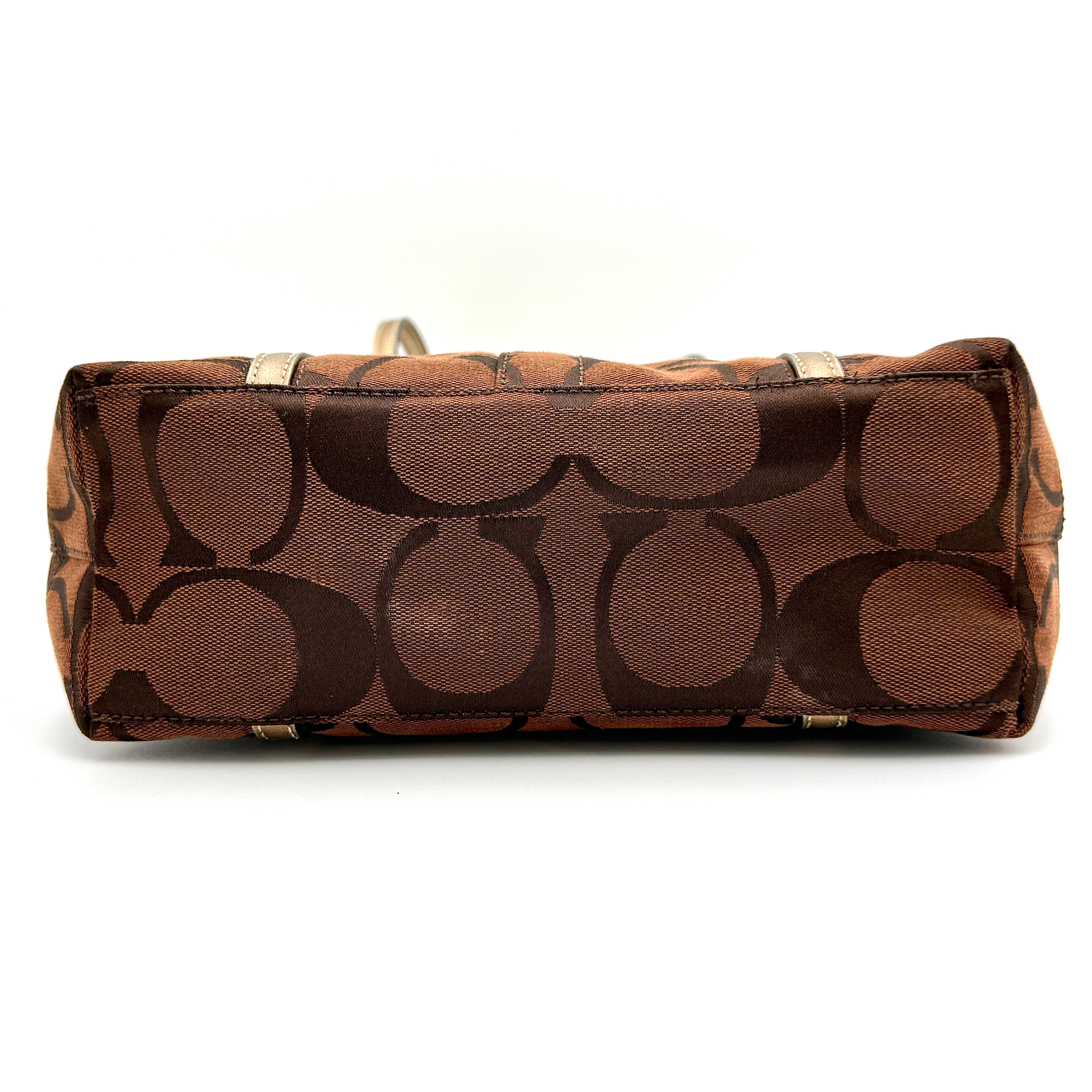 Coach Signature Stripe Tote Bag in rich brown monogram canvas with metallic gold leather handles, photographed upright against a clean background.