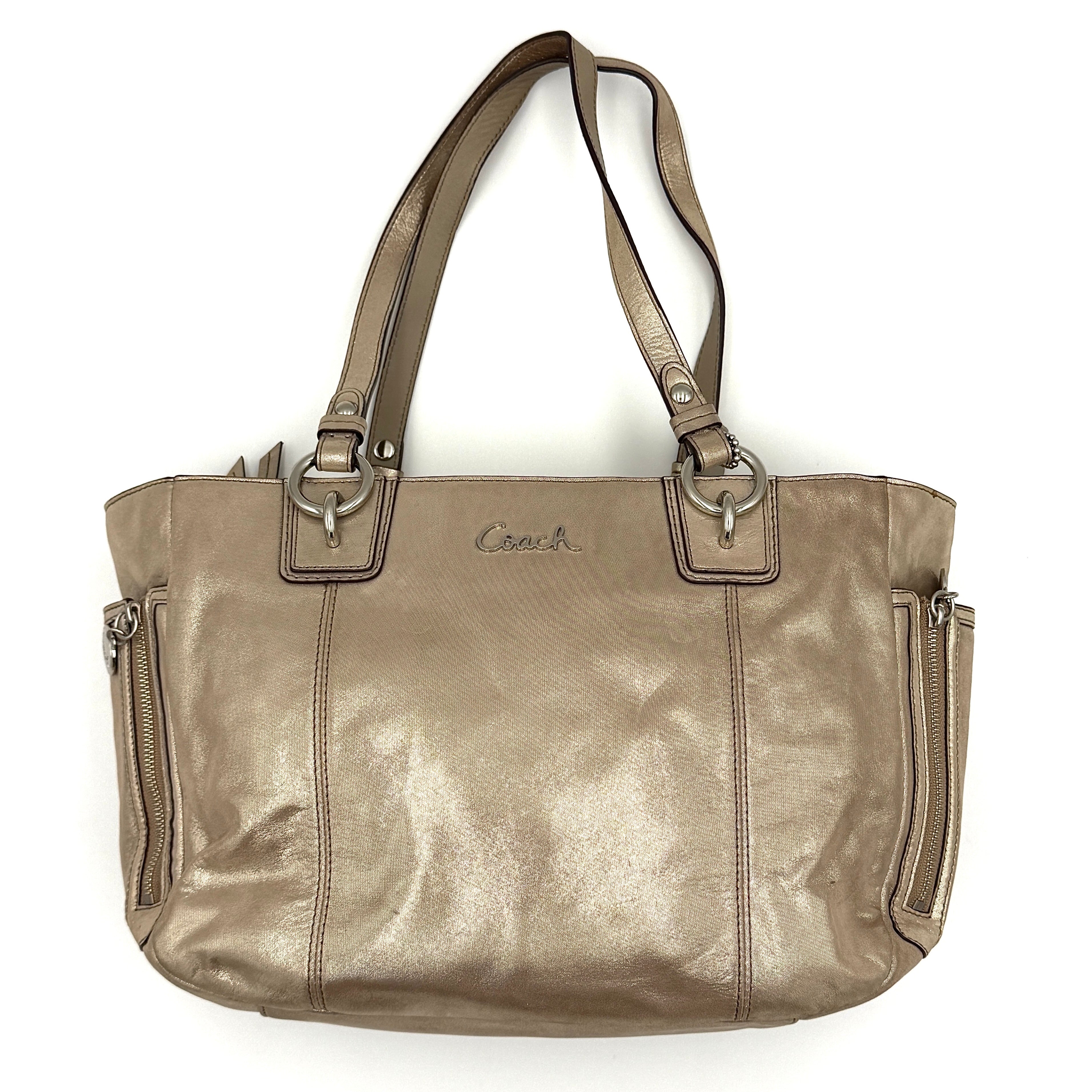 Coach Shimmer Gallery Tote in metallic beige leather with silver-tone hardware and dual top handles, set against a white background.
