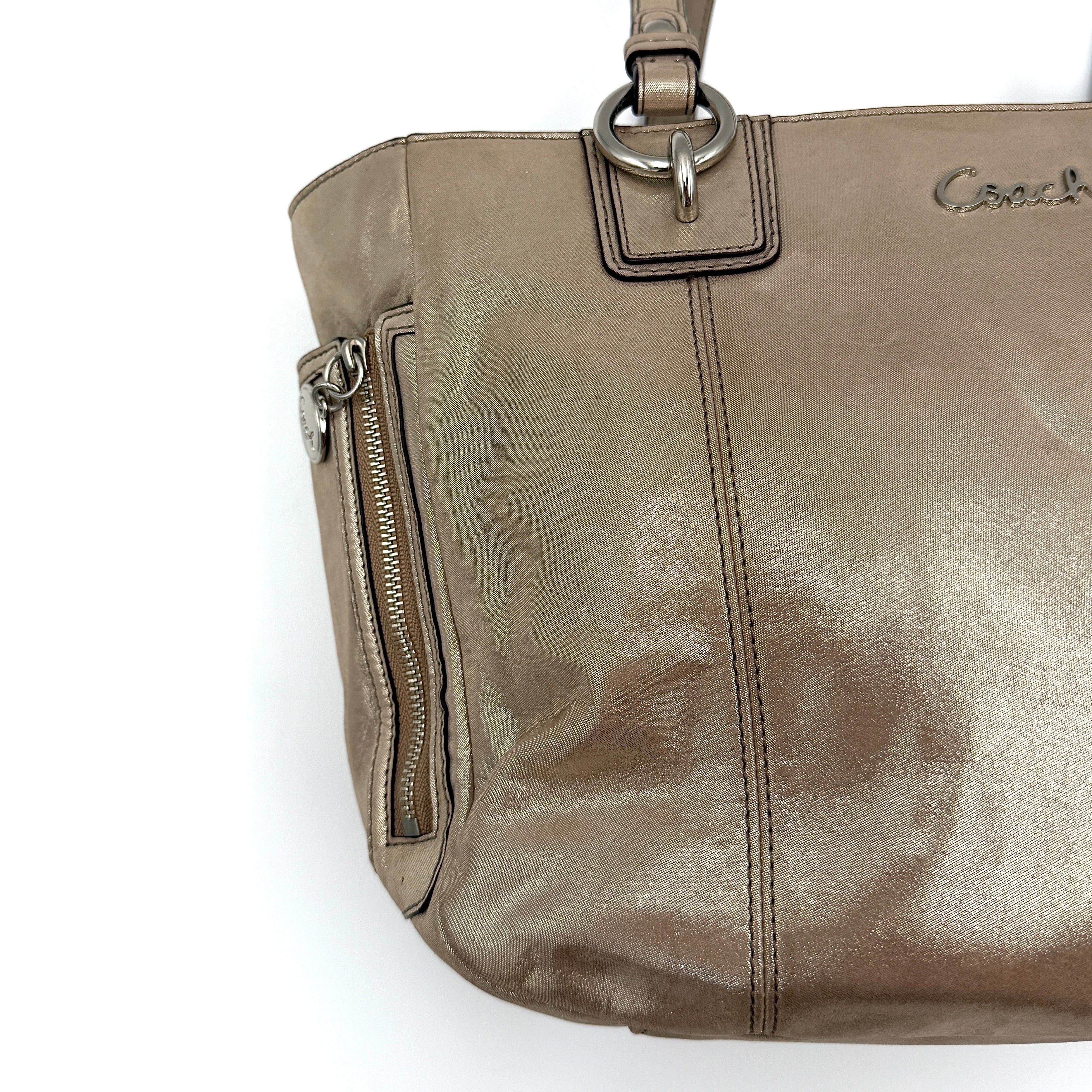 Coach Shimmer Gallery Tote in metallic beige leather with silver-tone hardware and dual top handles, set against a white background.