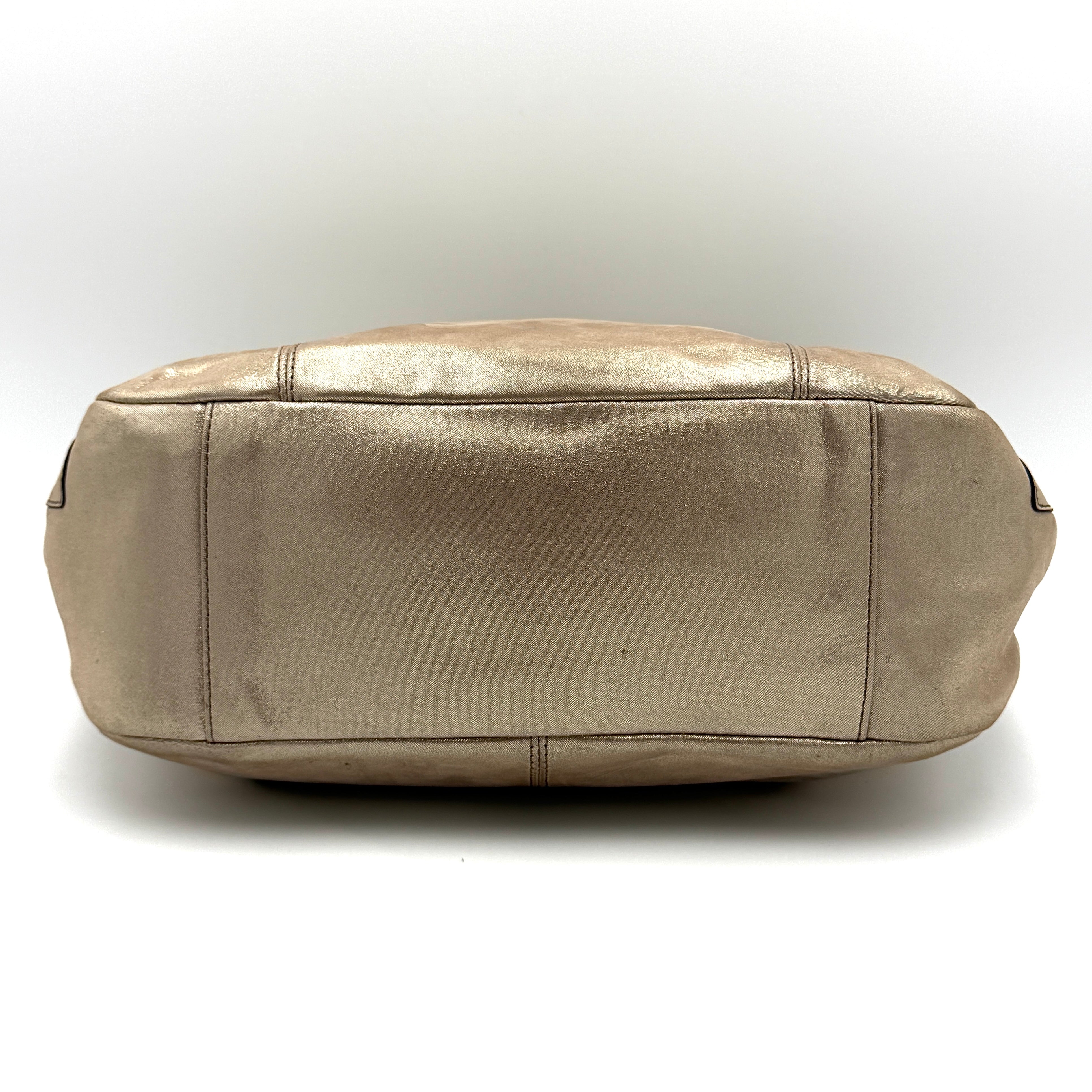 Coach Shimmer Gallery Tote in metallic beige leather with silver-tone hardware and dual top handles, set against a white background.