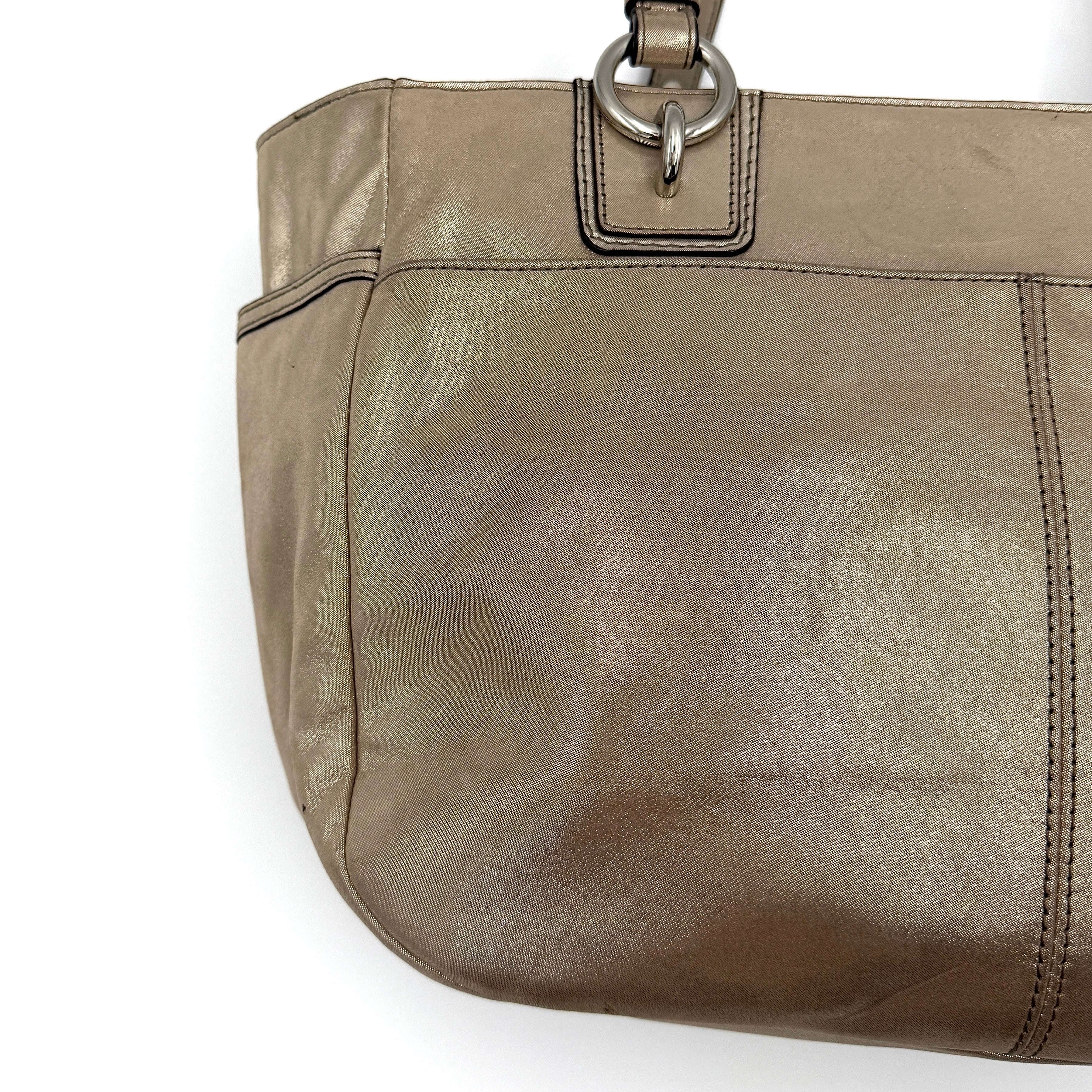 Coach Shimmer Gallery Tote in metallic beige leather with silver-tone hardware and dual top handles, set against a white background.