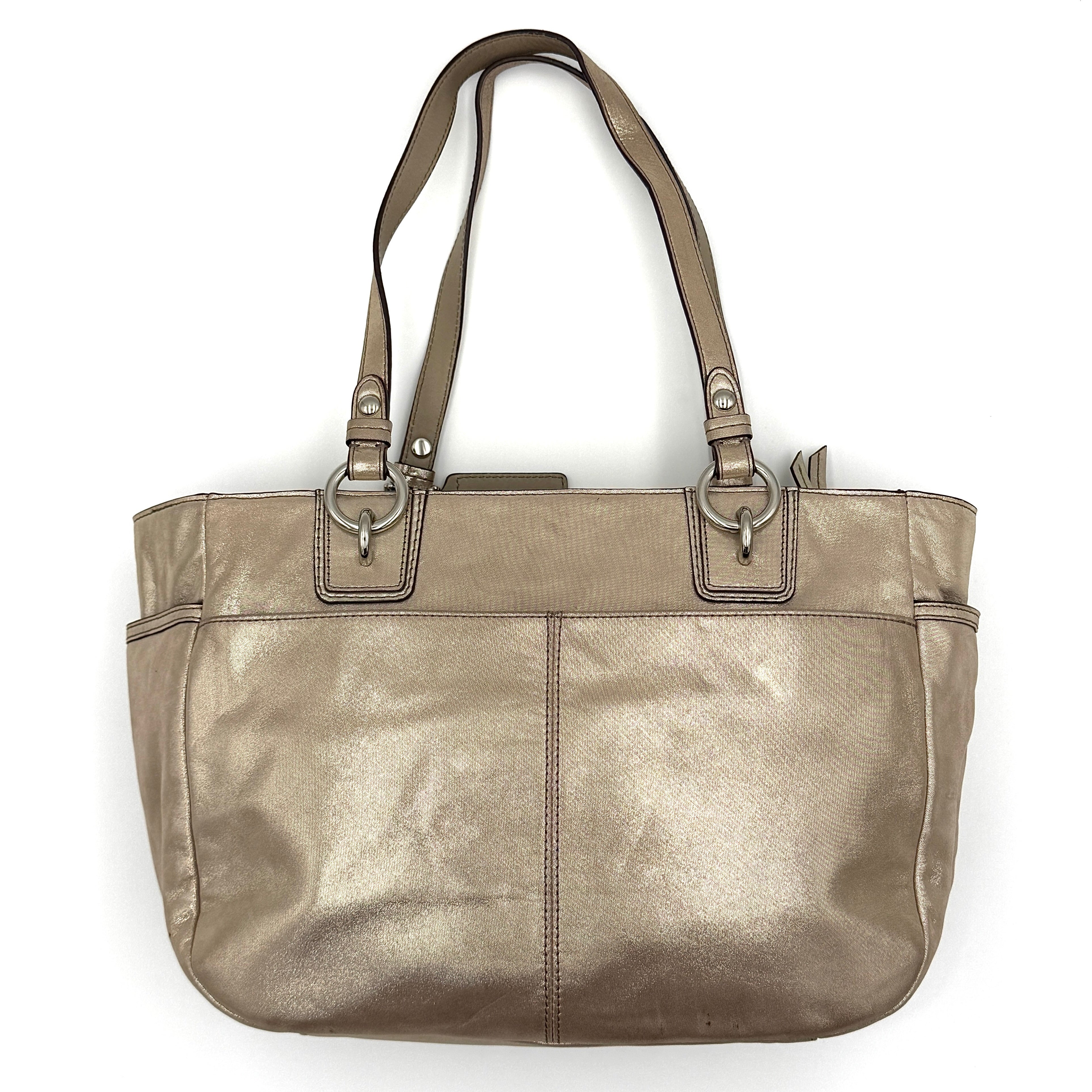 Coach Shimmer Gallery Tote in metallic beige leather with silver-tone hardware and dual top handles, set against a white background.