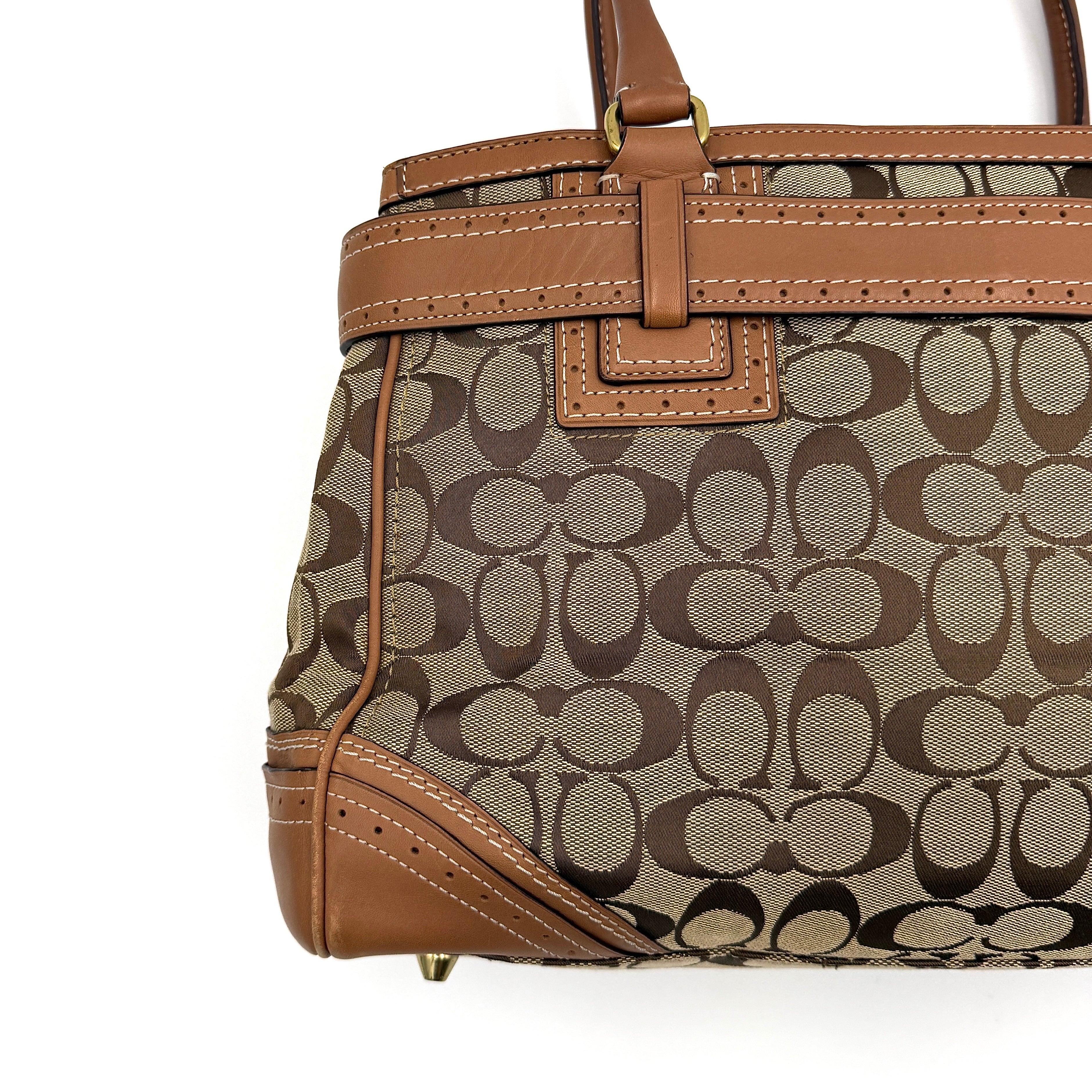 Coach Signature Hampton Carryall Shoulder Bag in beige and tan canvas with caramel leather trim, gold hardware, and tassel detail, shown standing upright.