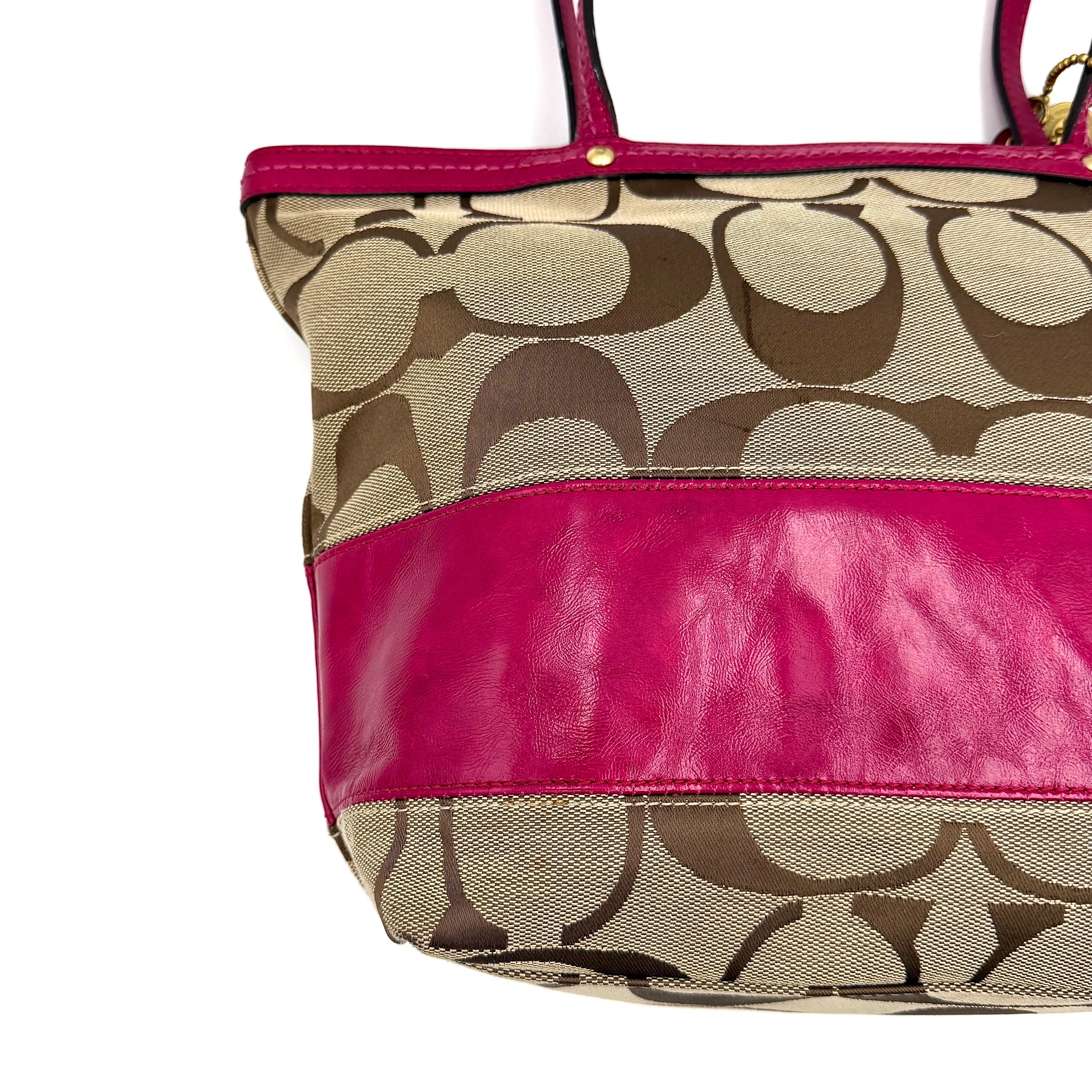 Coach Signature Stripe Tote Bag in beige monogram canvas with bold pink leather accents and top handles.