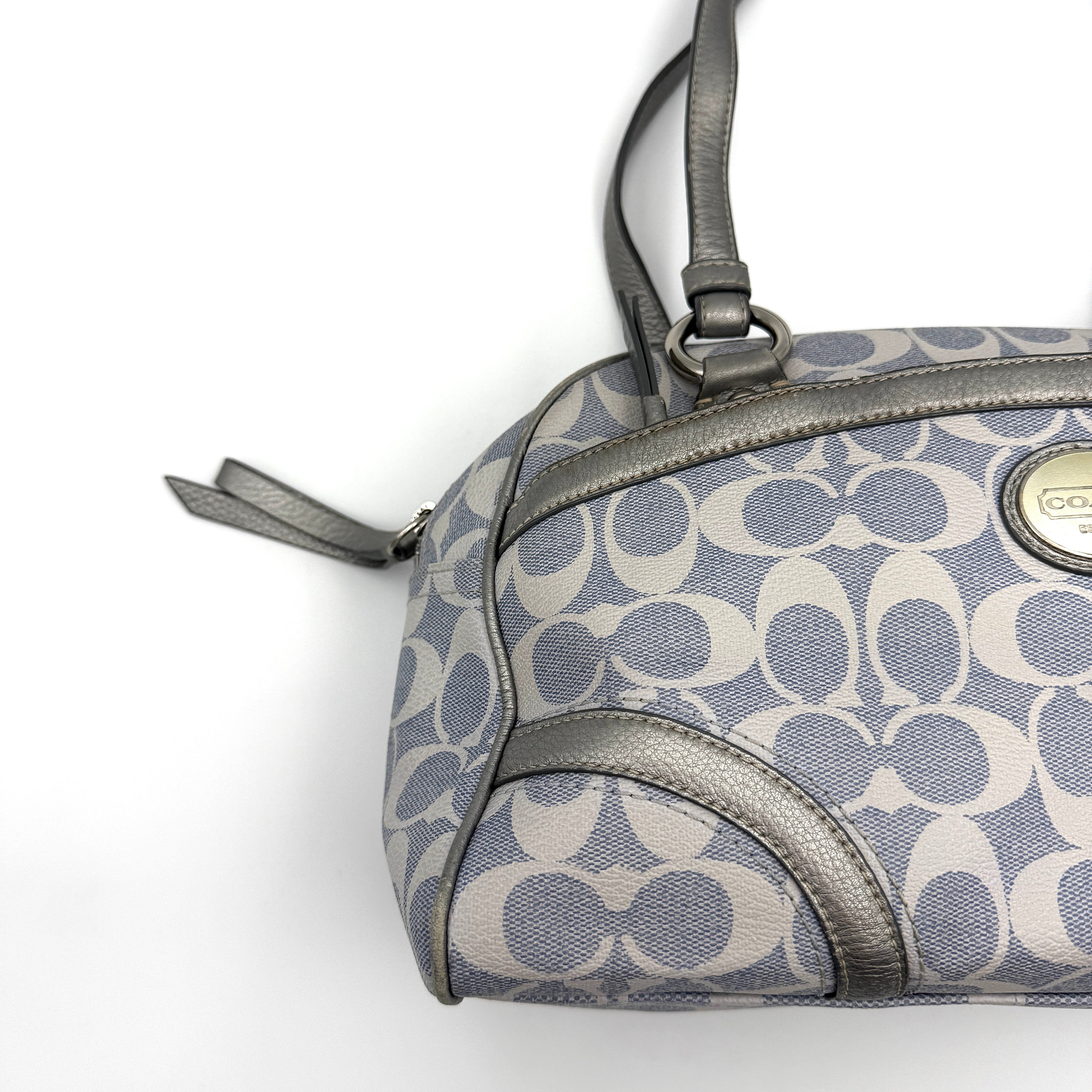Coach Signature Peyton Satchel in light blue and grey canvas with metallic leather trim and double handles, shown against a white background.