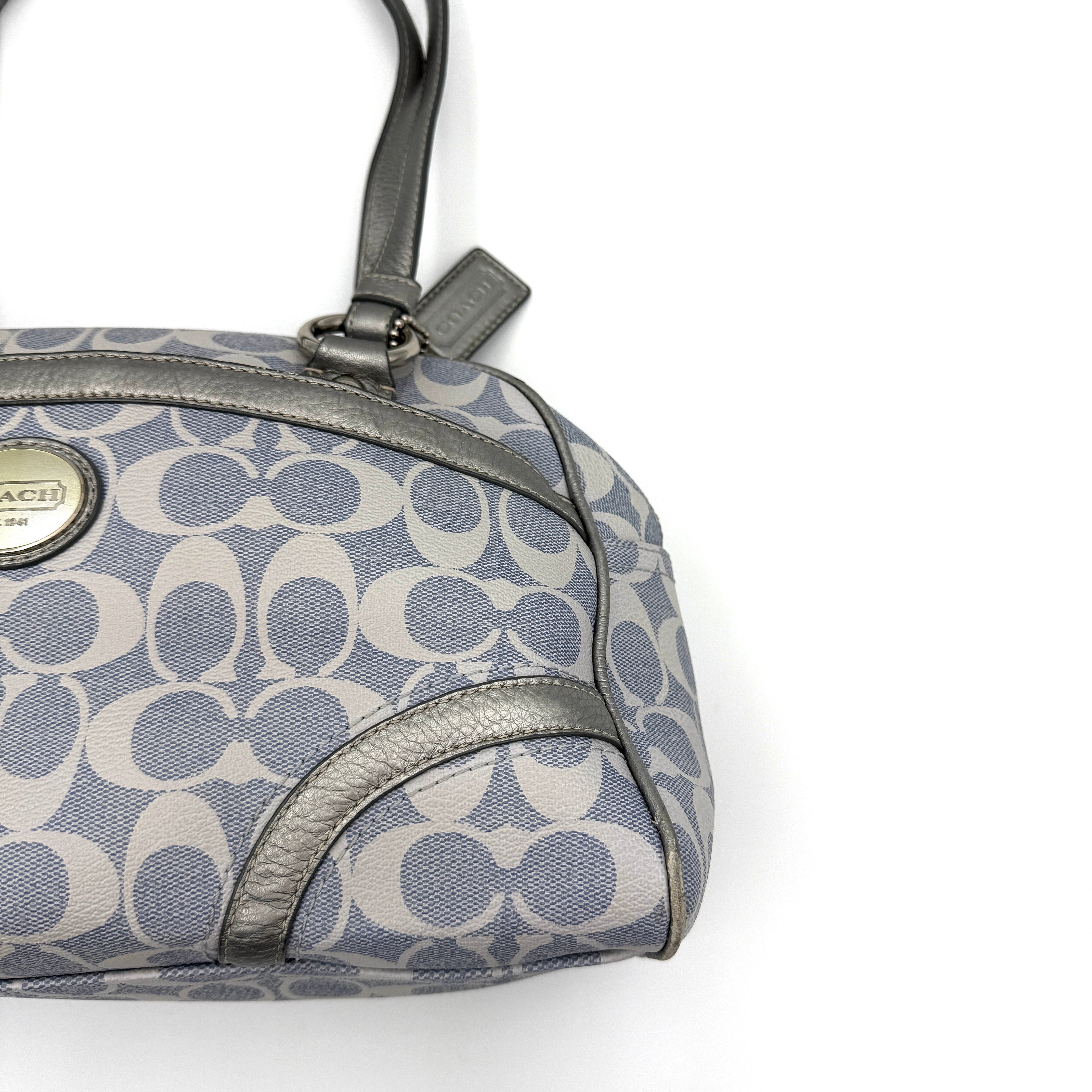 Coach Signature Peyton Satchel in light blue and grey canvas with metallic leather trim and double handles, shown against a white background.