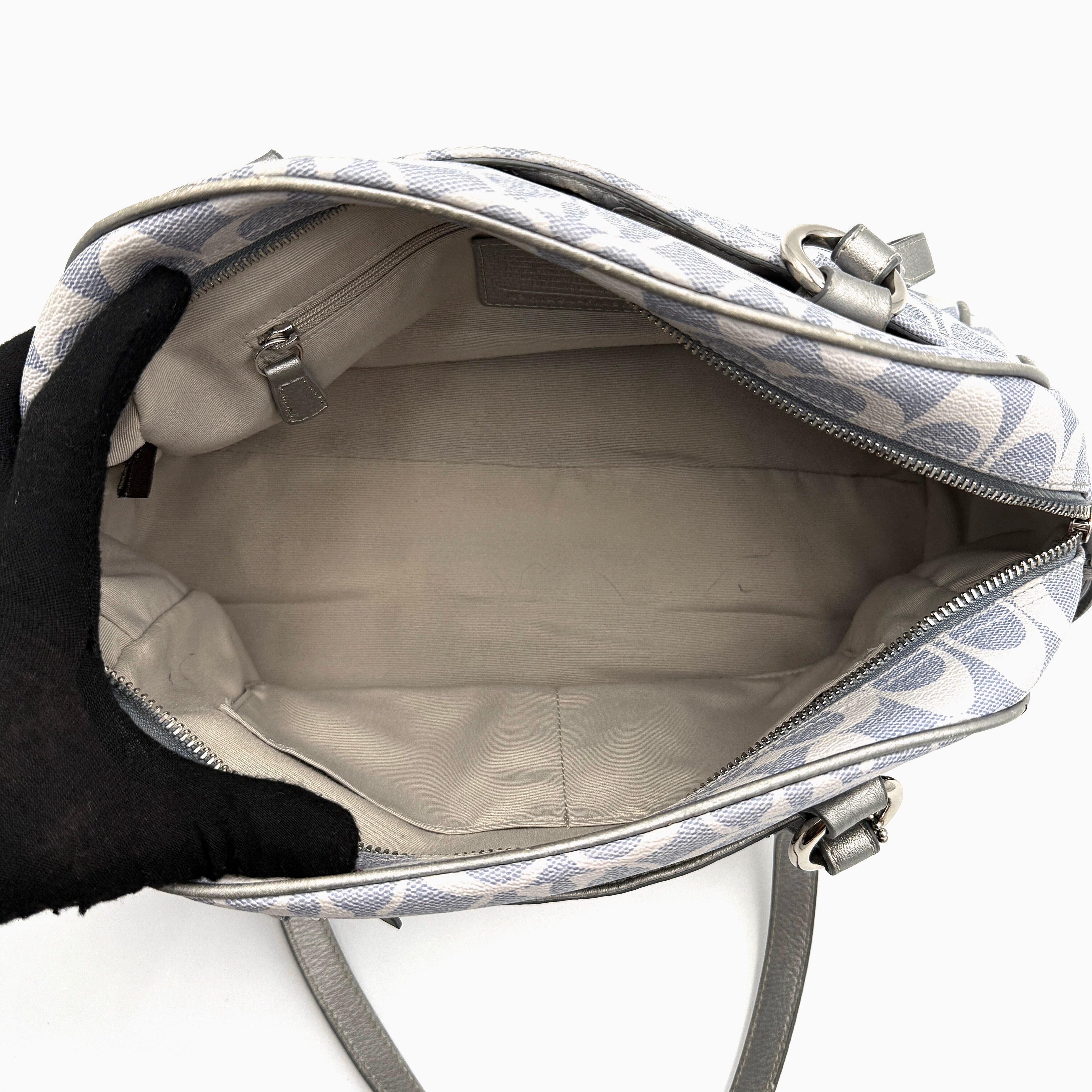 Coach Signature Peyton Satchel in light blue and grey canvas with metallic leather trim and double handles, shown against a white background.