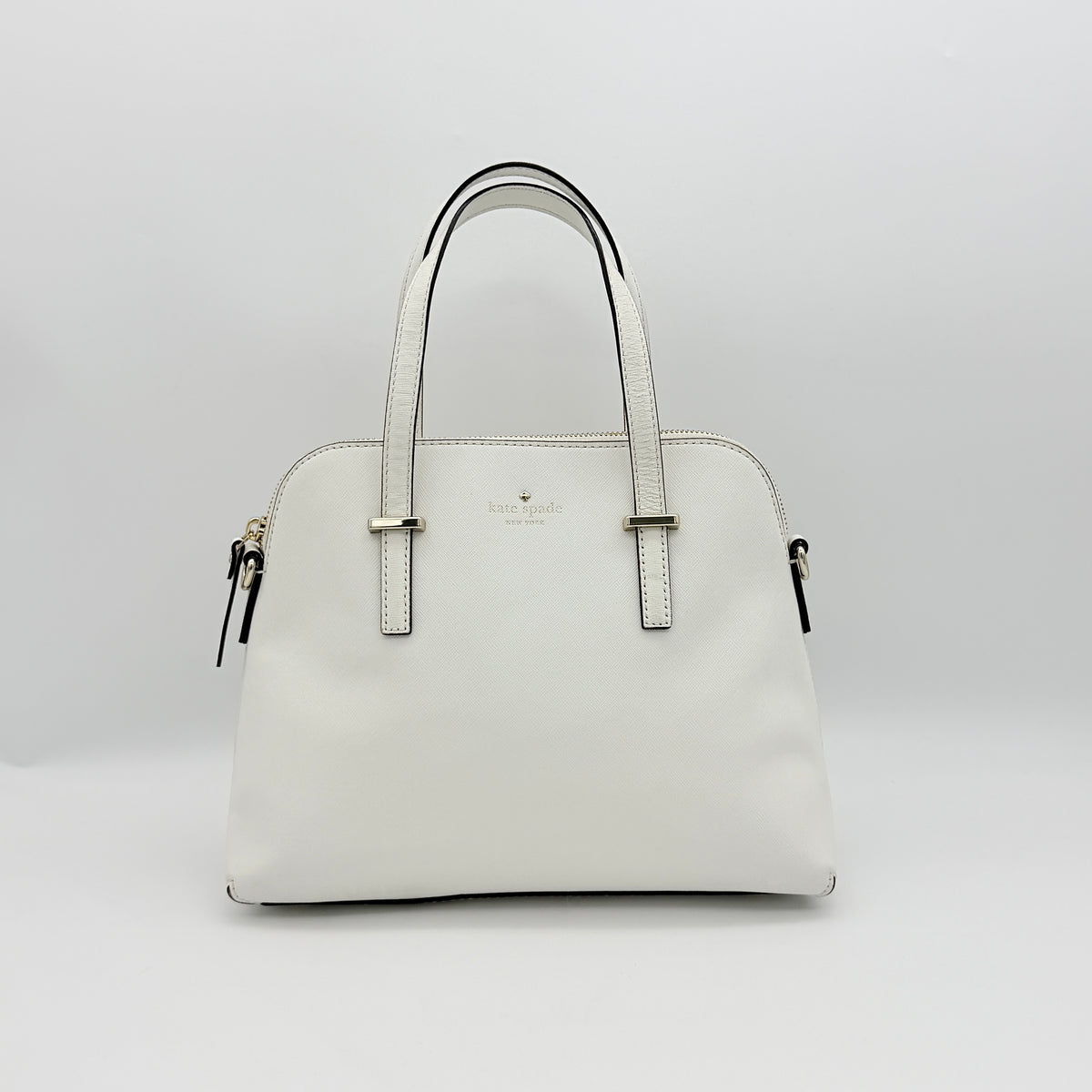 Top view of the Kate Spade Cedar Street Maise satchel in ivory, showing its spacious polka dot interior and zip pocket detail.