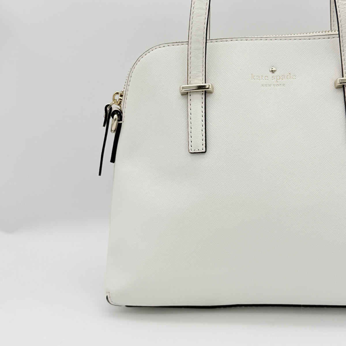 Top view of the Kate Spade Cedar Street Maise satchel in ivory, showing its spacious polka dot interior and zip pocket detail.