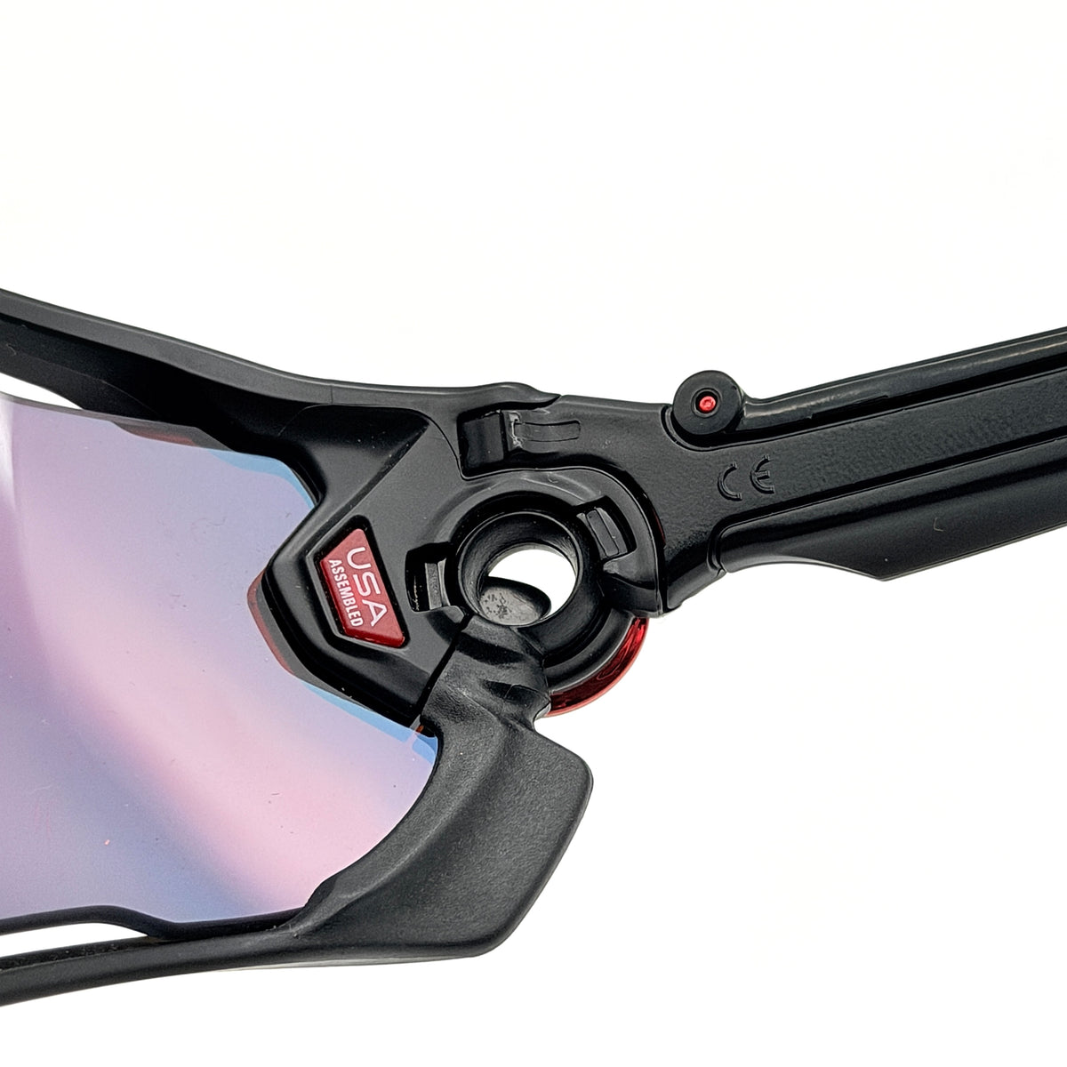 Oakley Jawbreaker Prizm sunglasses in matte black and red with pink-red Prizm lenses, shown with a black Oakley hard case and extra nose pad.