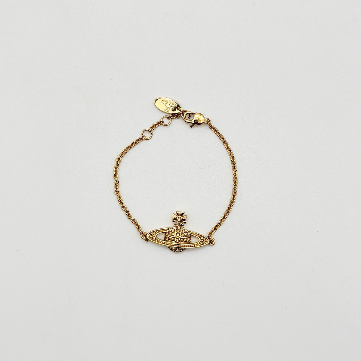 Vivienne Westwood gold rhinestone Orb bracelet with original box, dust bag, and authenticity card arranged on a white background.