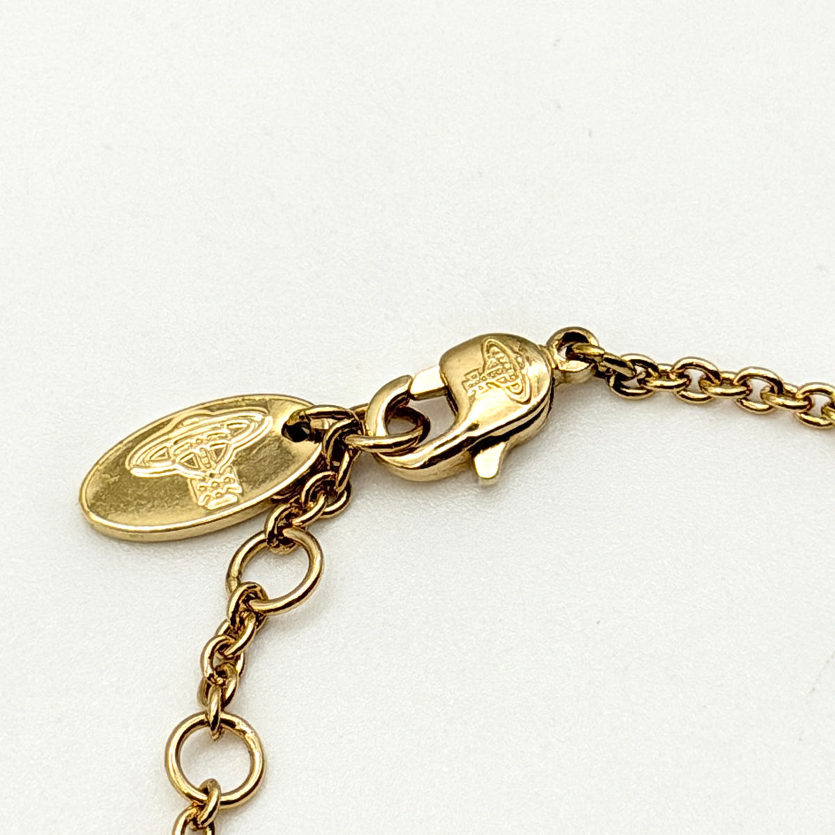 Vivienne Westwood gold rhinestone Orb bracelet with original box, dust bag, and authenticity card arranged on a white background.