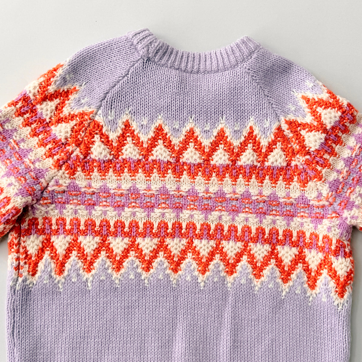 Coach Fair Isle Ski Sweater in lilac with orange and cream geometric pattern and COACH logo across the chest.