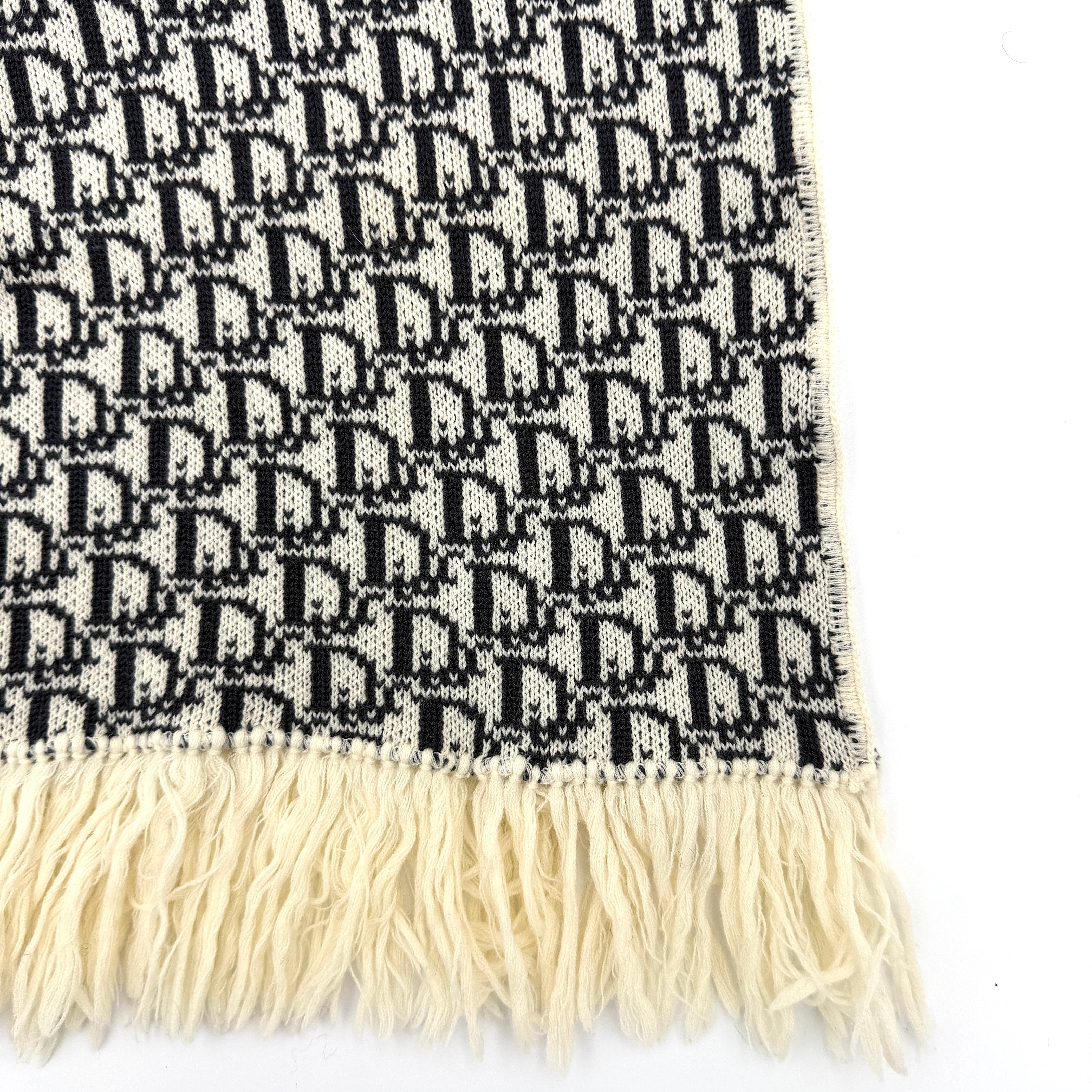 Dior Trotter Monogram wool scarf in white and black with all-over Dior logo pattern and fringe trim, elegantly displayed.