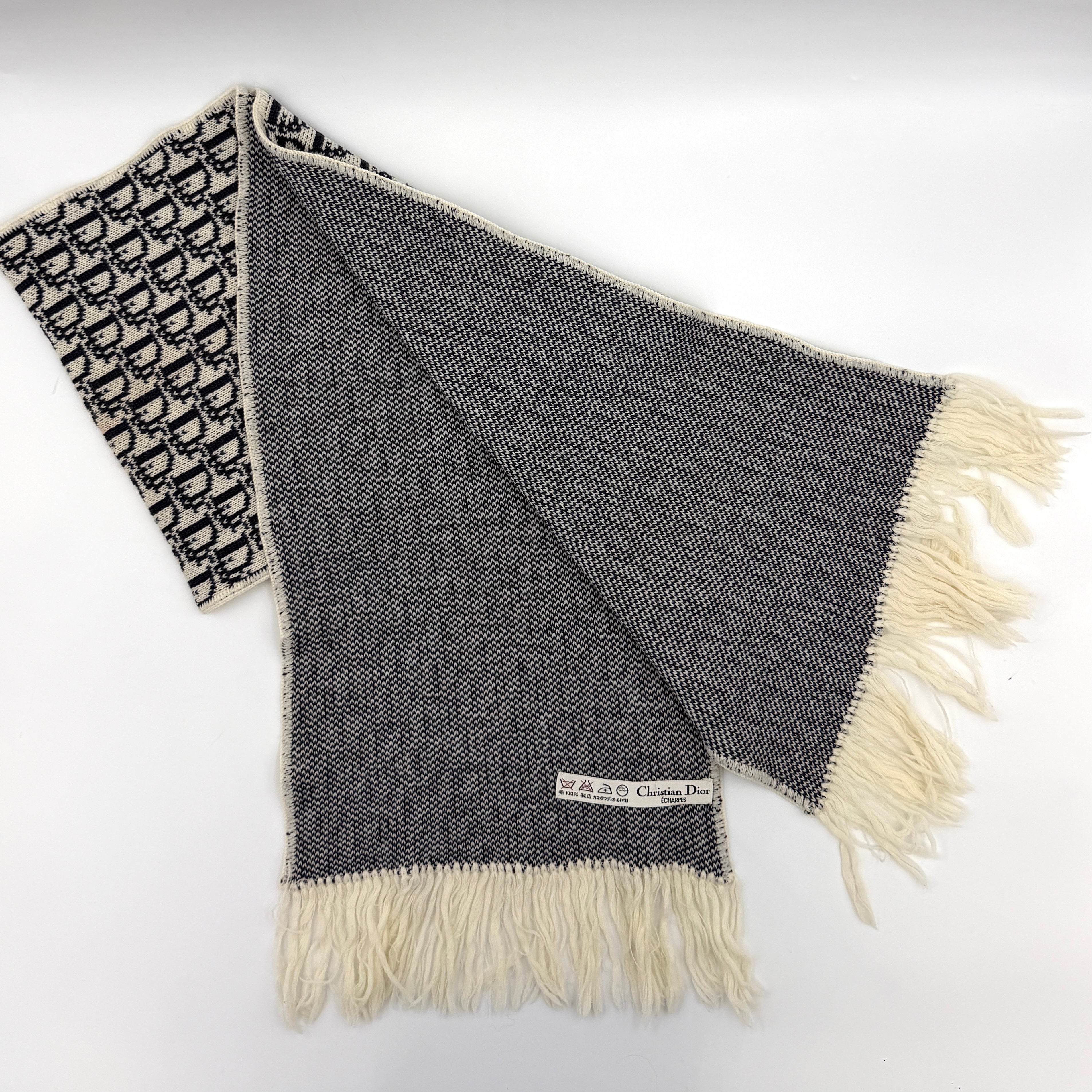 Dior Trotter Monogram wool scarf in white and black with all-over Dior logo pattern and fringe trim, elegantly displayed.