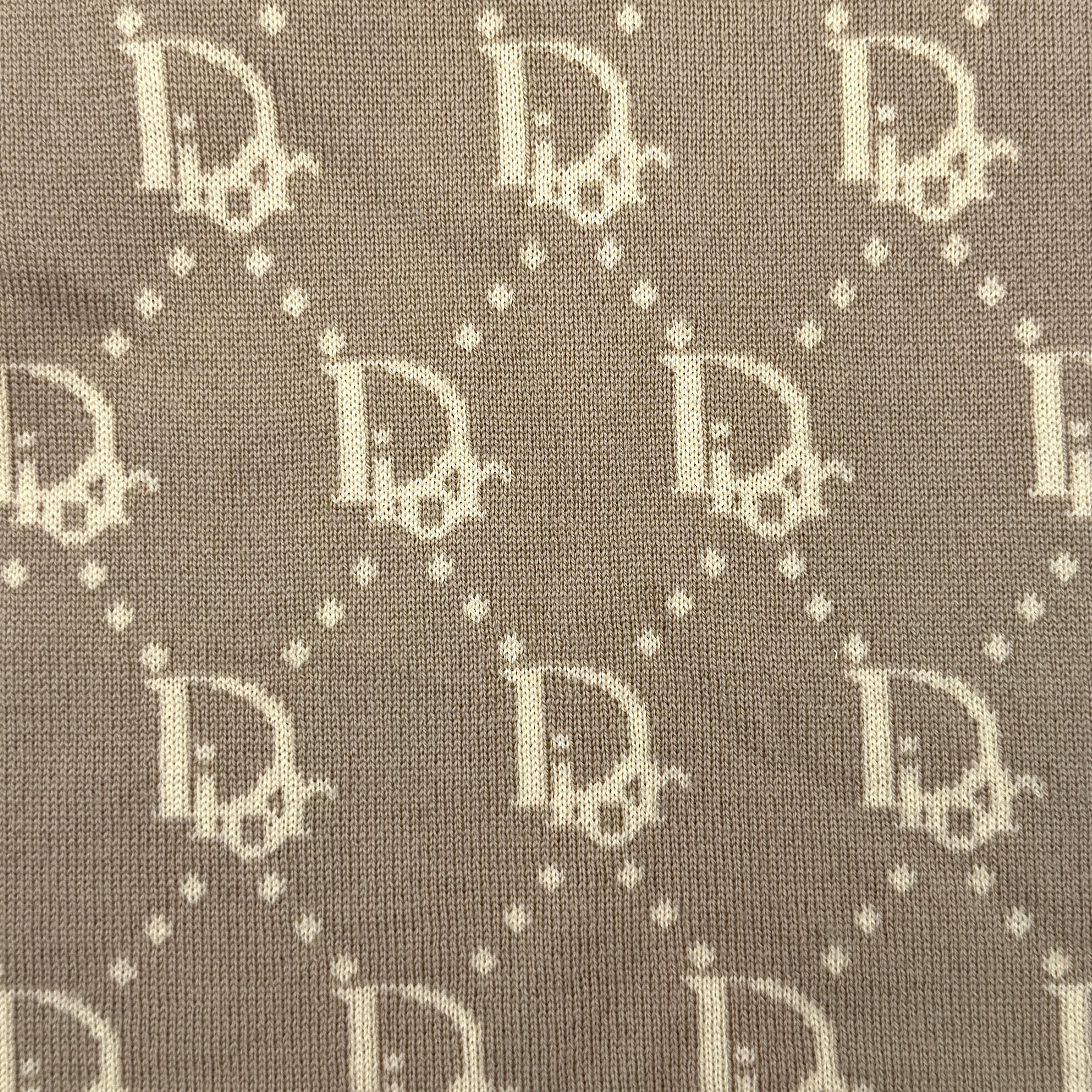 Beige Dior wool scarf featuring an all-over monogram jacquard pattern, elegantly displayed to reveal both sides' colour contrast.