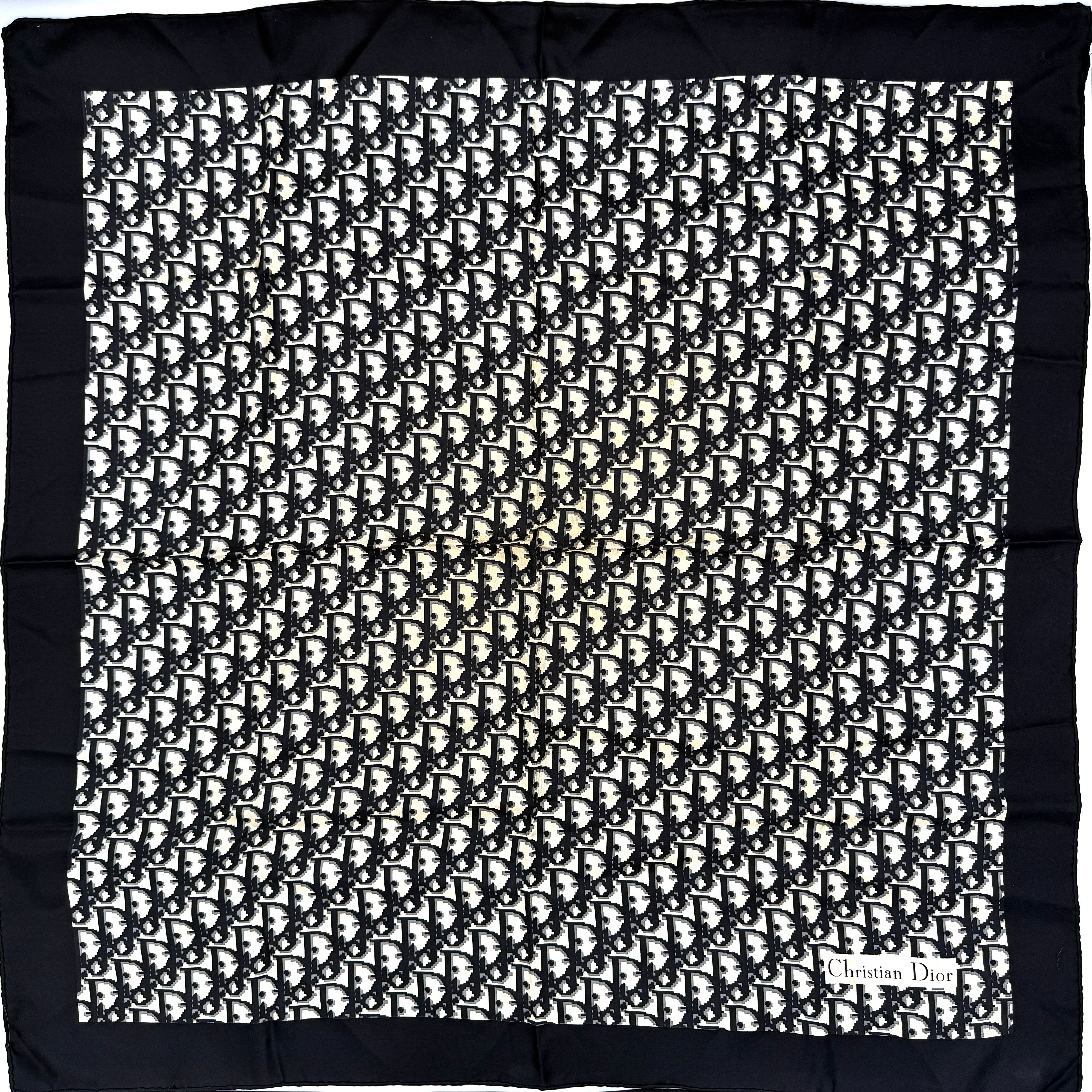 Dior monogram silk scarf in black and cream with graphic logo pattern and bold black border.