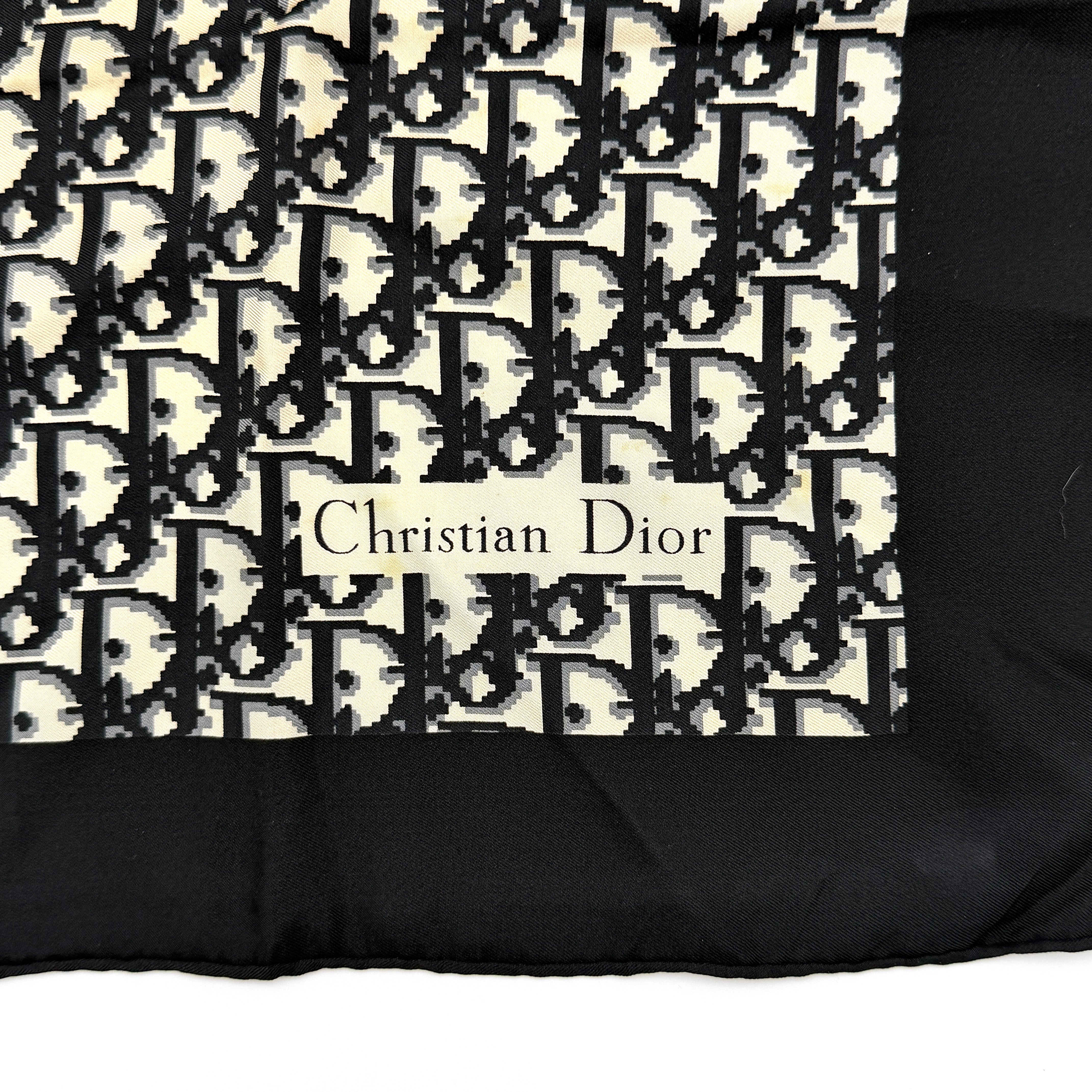 Dior monogram silk scarf in black and cream with graphic logo pattern and bold black border.