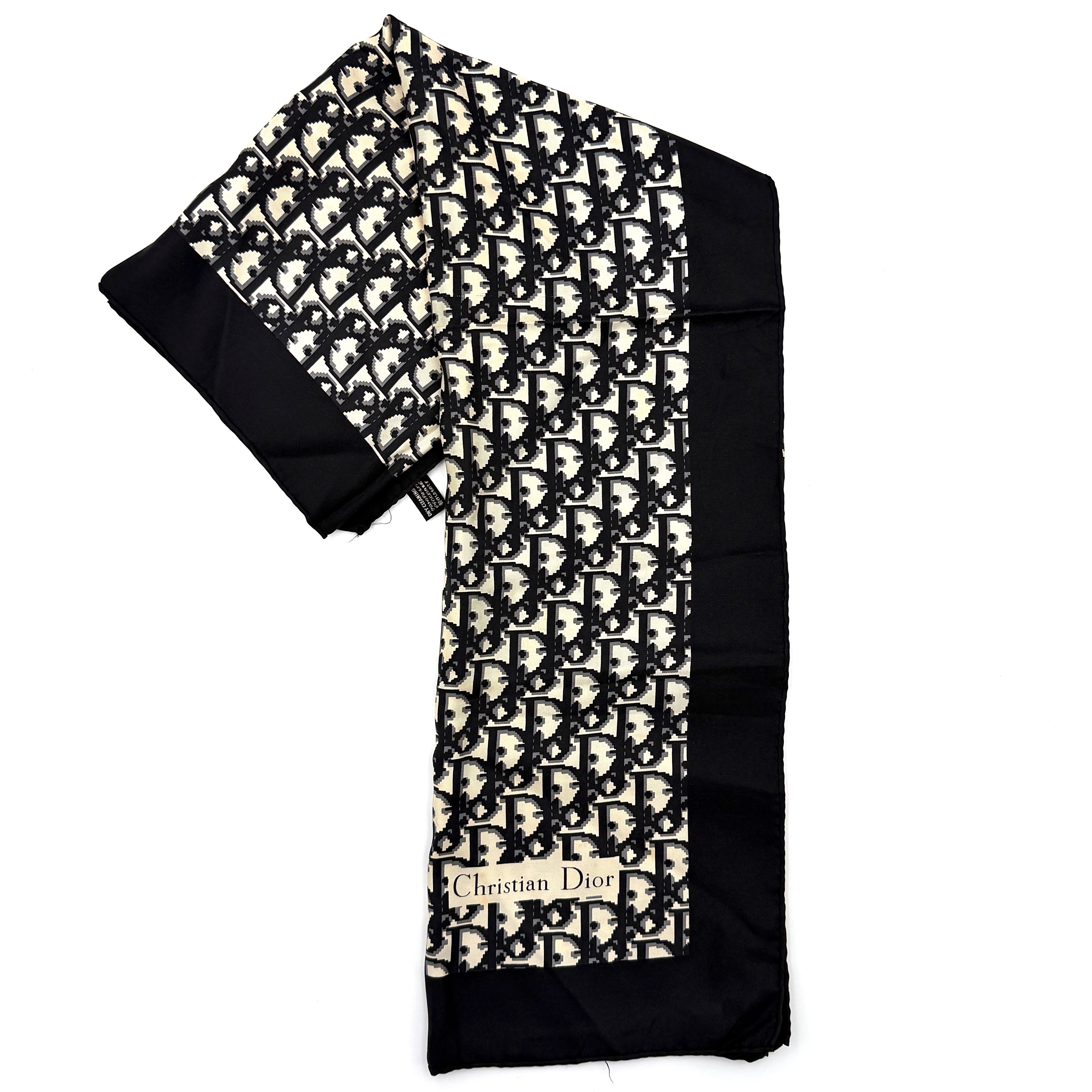 Dior monogram silk scarf in black and cream with graphic logo pattern and bold black border.