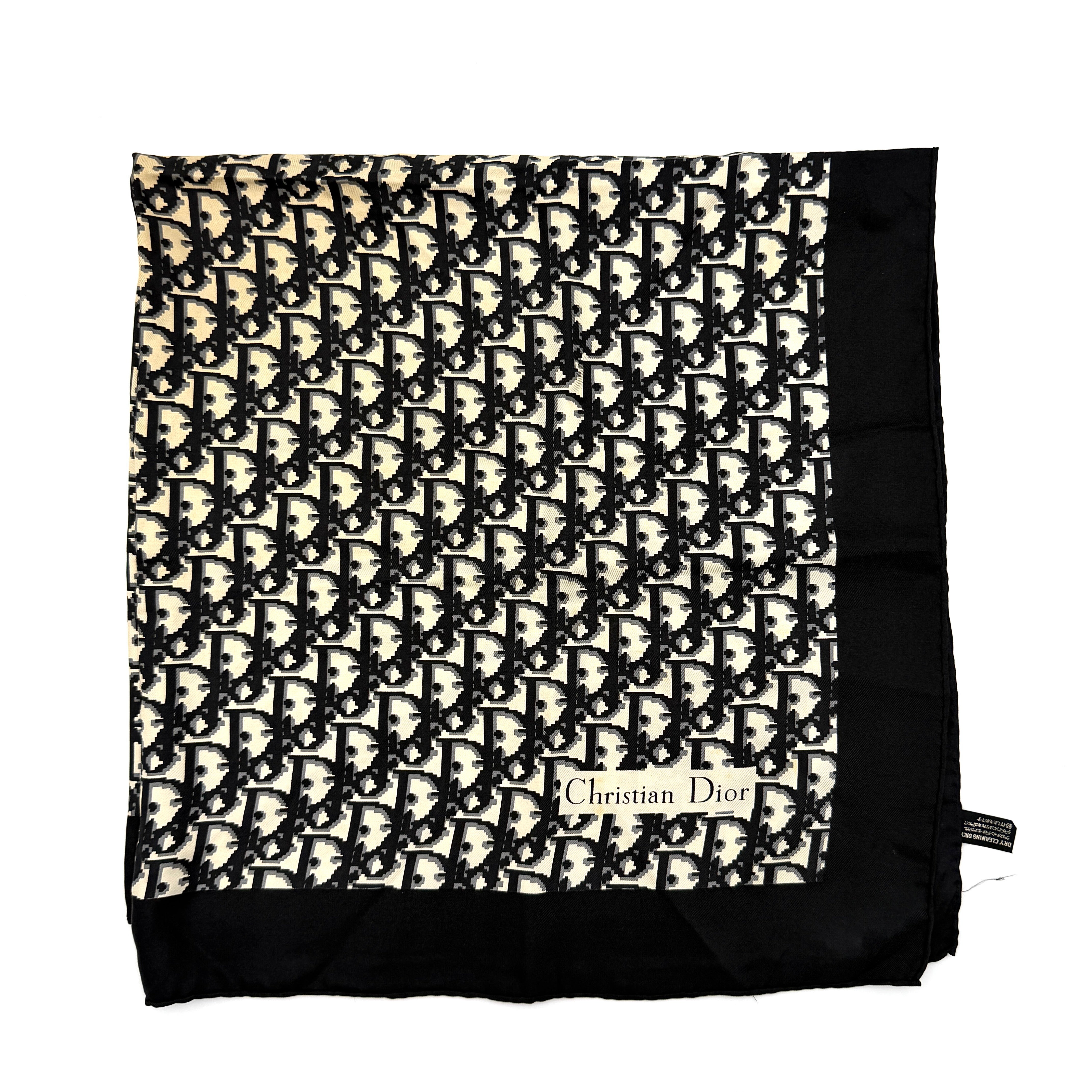 Dior monogram silk scarf in black and cream with graphic logo pattern and bold black border.