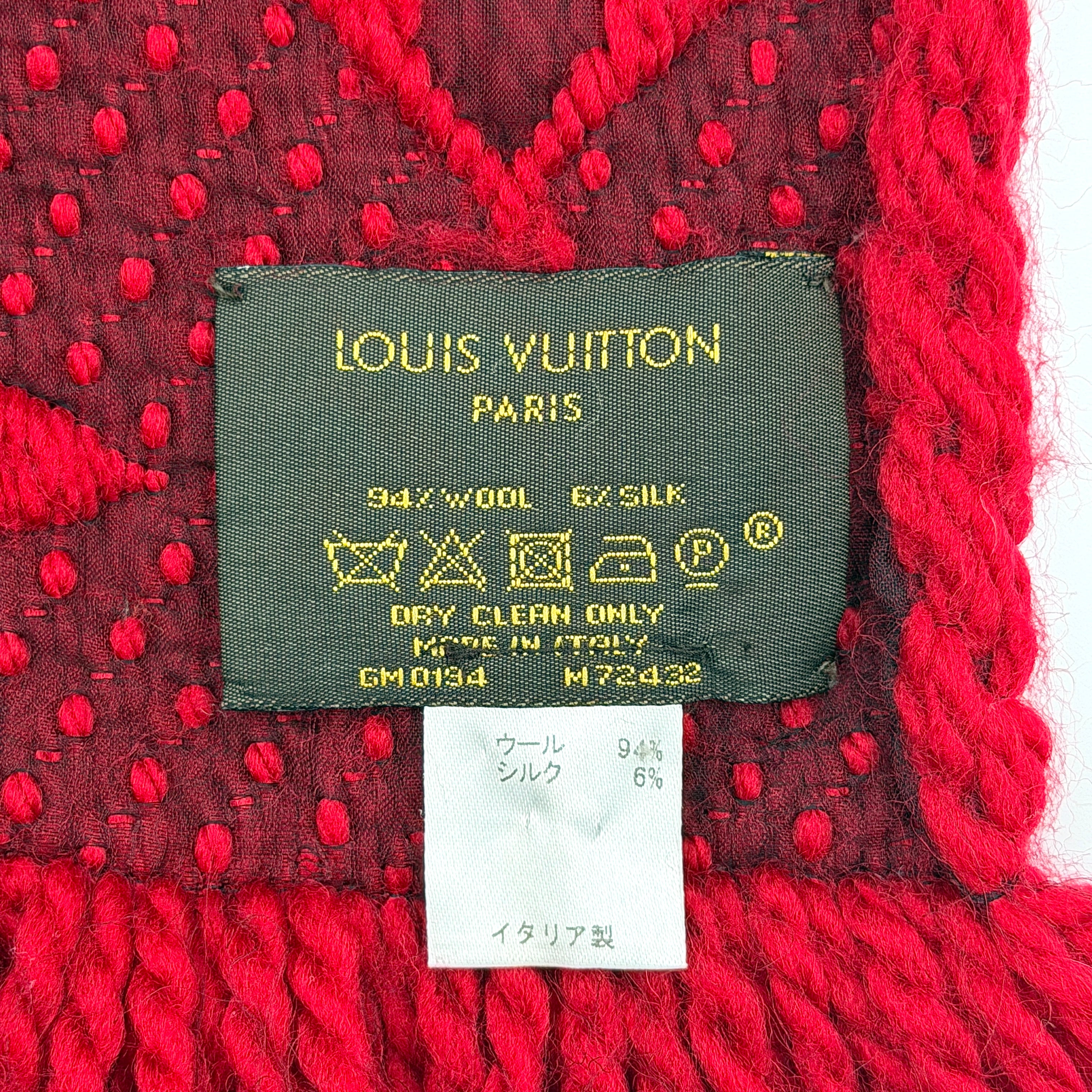 A luxurious Louis Vuitton Monogram Echarpe wool scarf in vibrant red, distinguished by its chunky texture, signature monogram pattern, and playful fringe edging.