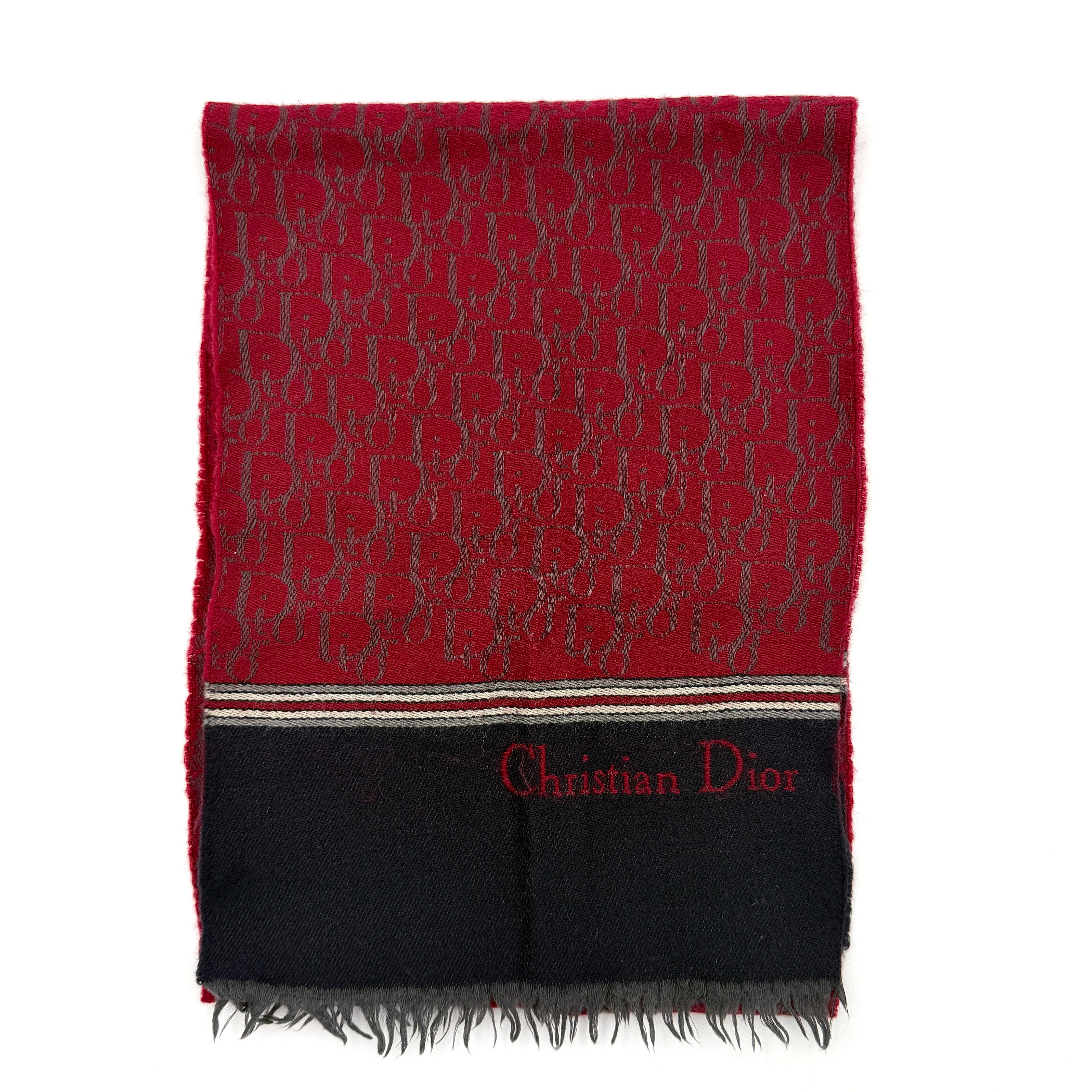 A red Dior Oblique Trotter wool scarf with all-over monogram pattern, navy border, stripe detail, and fringe trim.