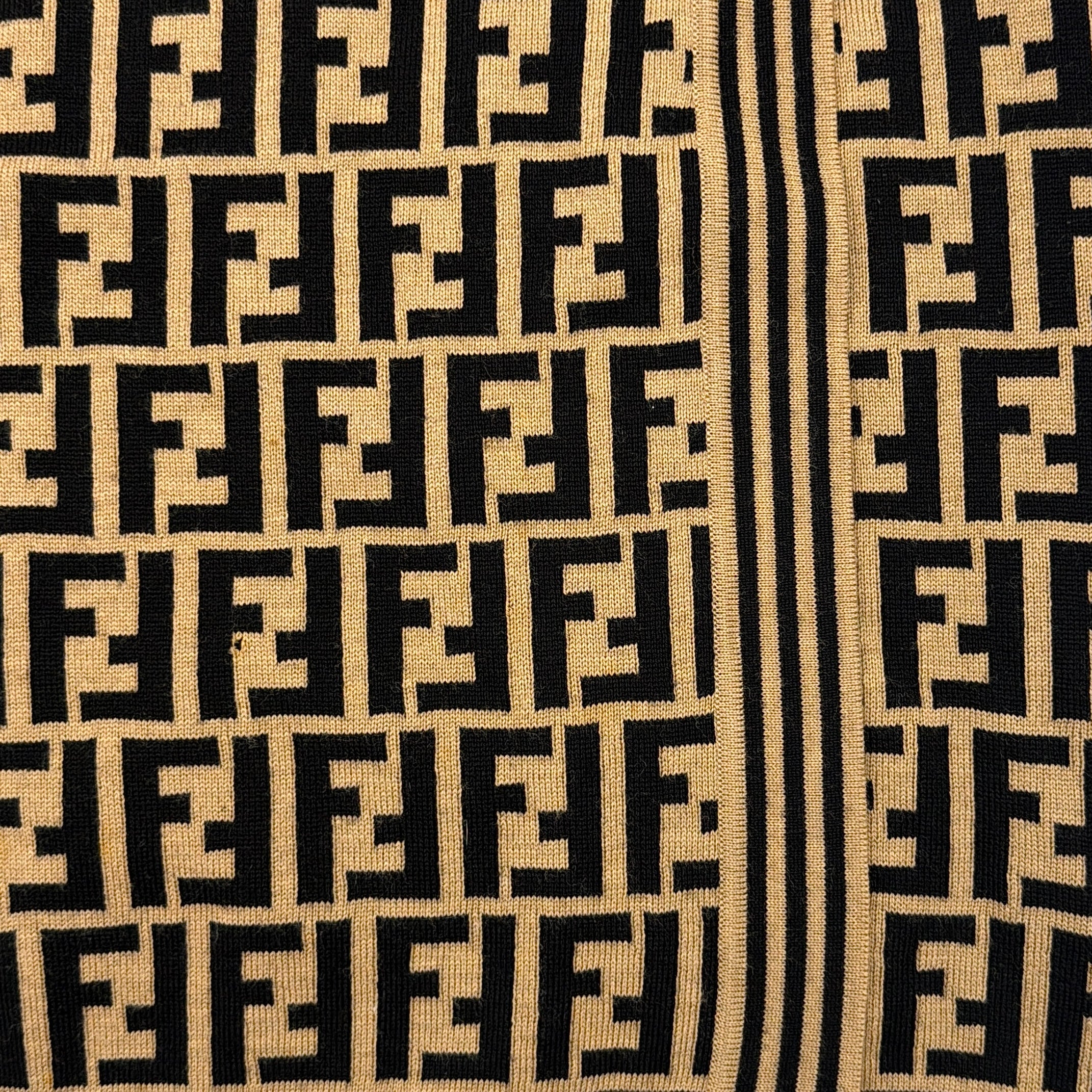 Fendi brown knit skirt with bold black FF Zucca monogram and side stripe detail, displayed flat to showcase its sculpted silhouette.
