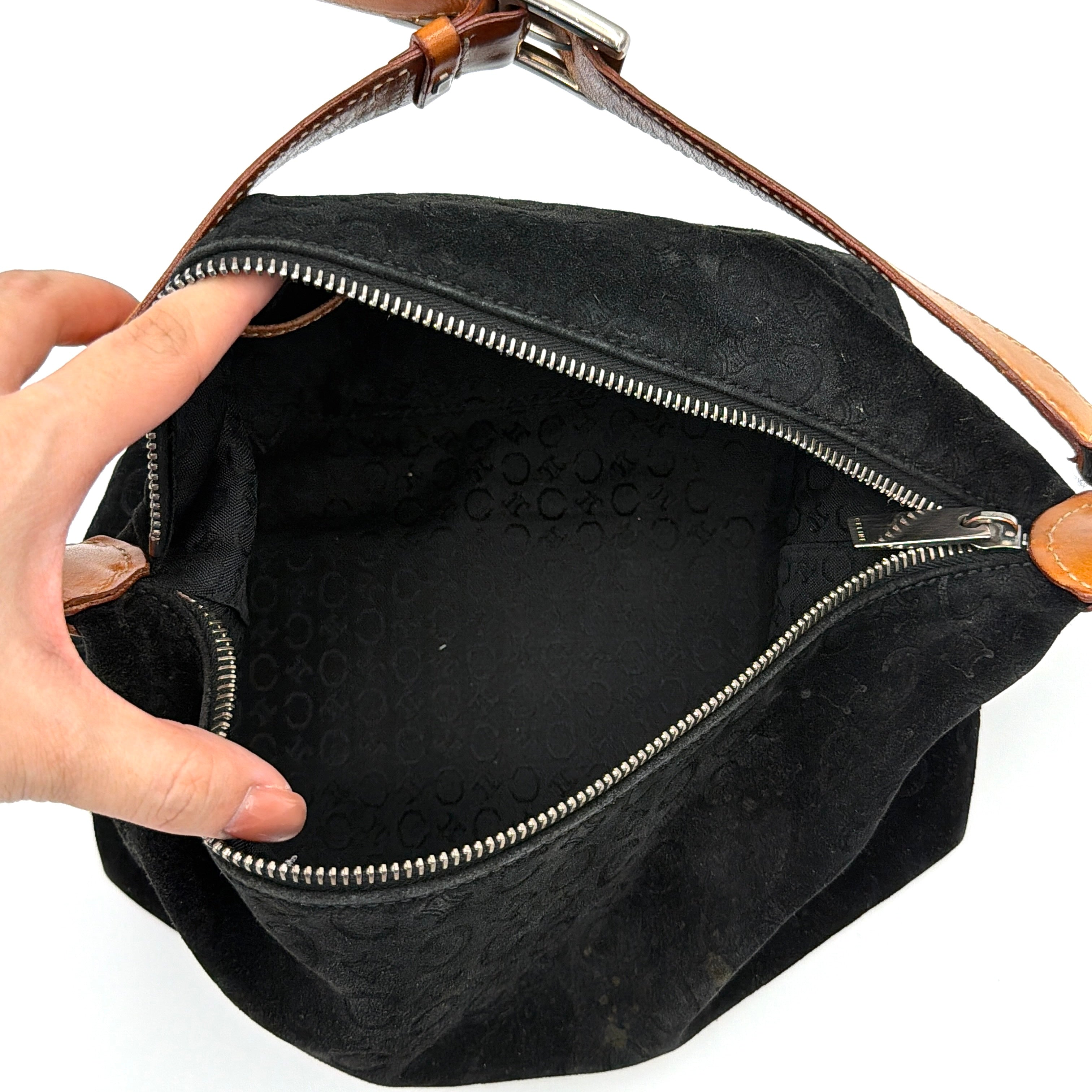 Celine black suede shoulder bag with embossed Triomphe motif, tan leather strap and silver-tone hardware, displayed from the front.