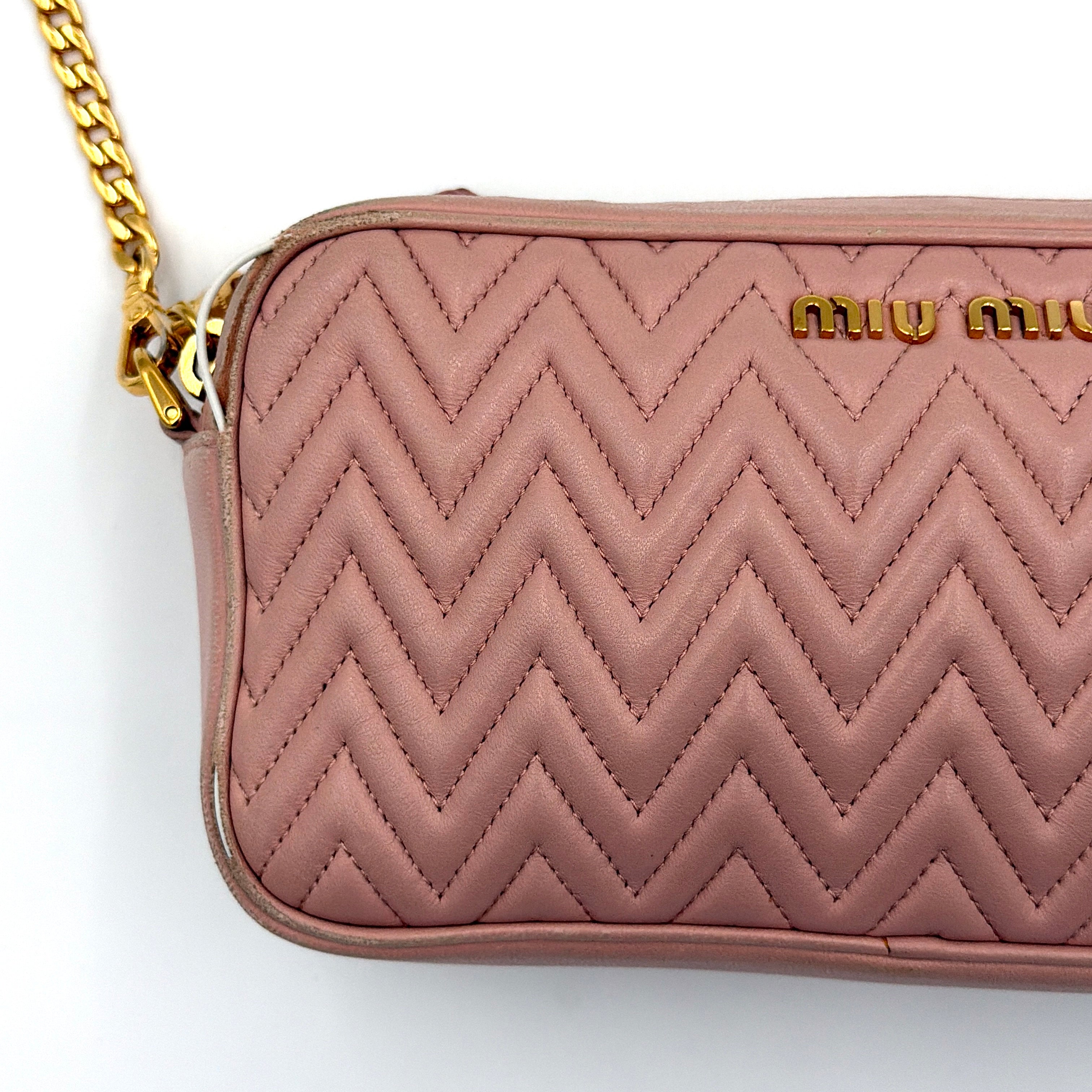 Miu Miu dusty pink quilted nappa mini crossbody bag with gold-tone chain strap and zip closure, showcased on a clean white background.