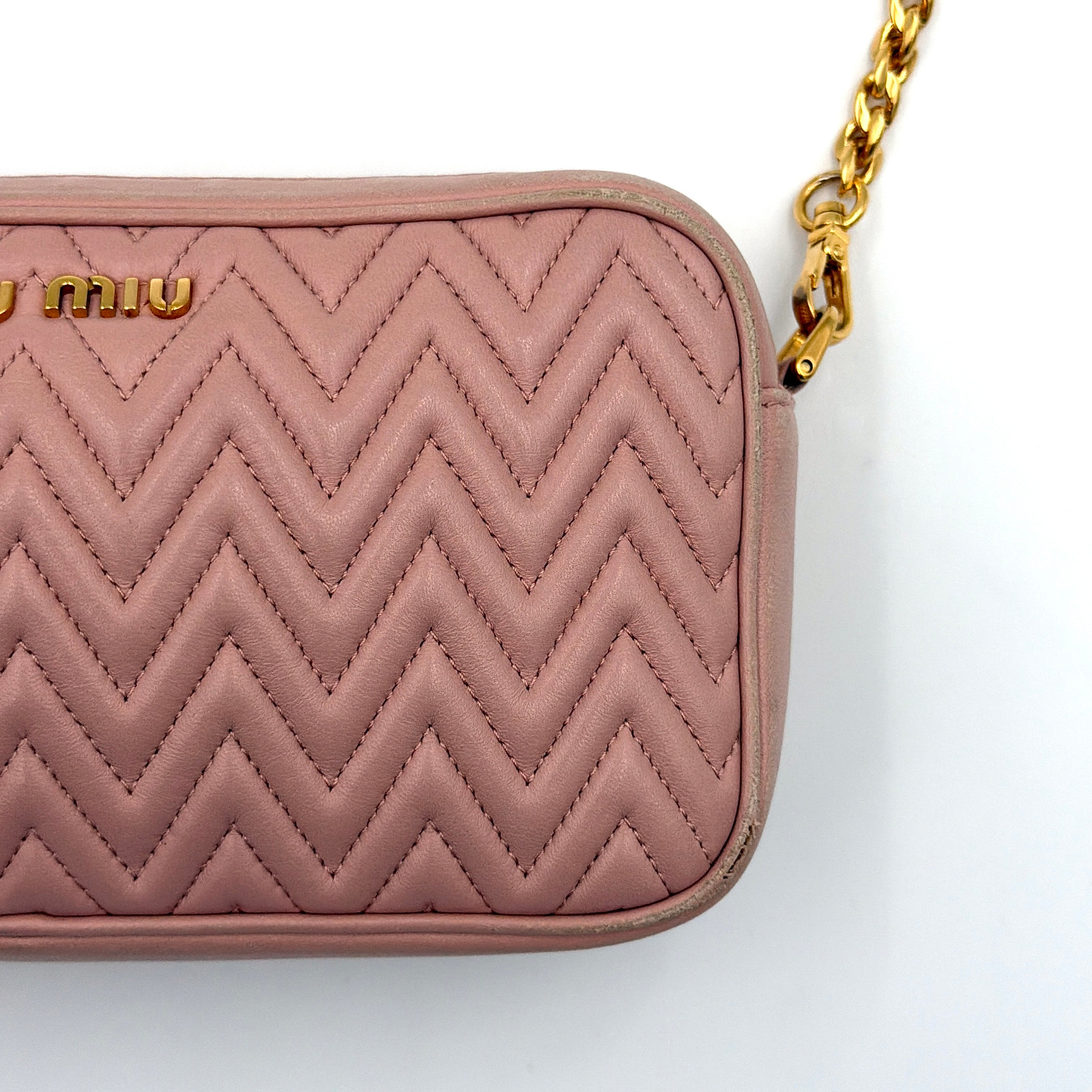 Miu Miu dusty pink quilted nappa mini crossbody bag with gold-tone chain strap and zip closure, showcased on a clean white background.