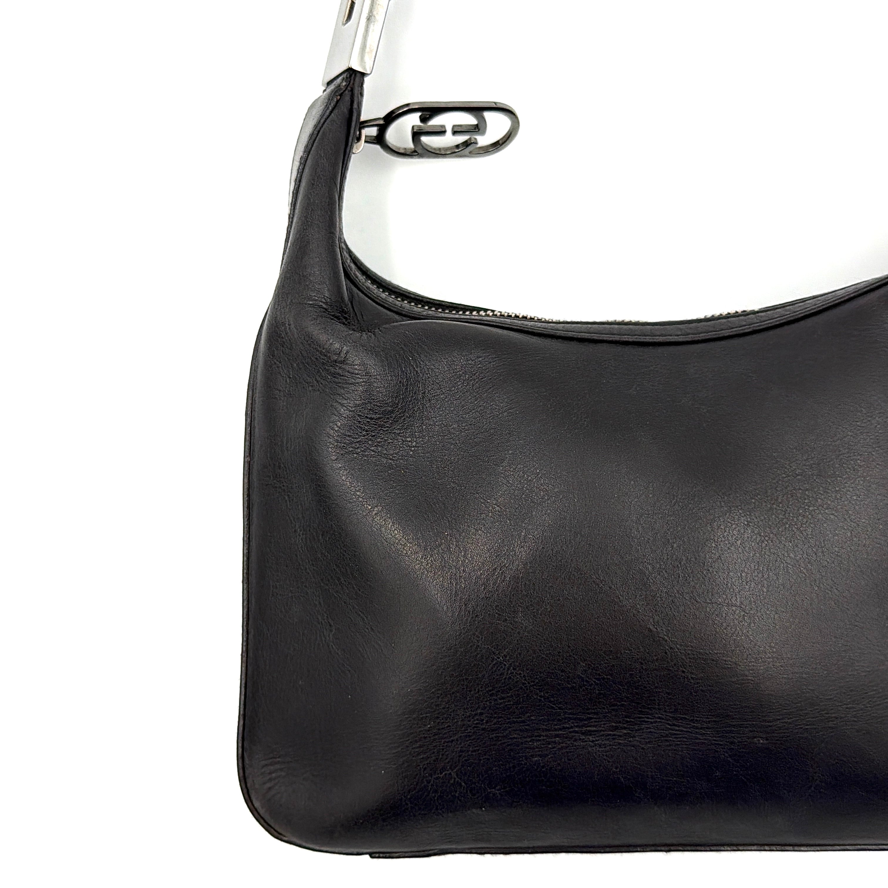 Gucci GG Leather Hobo Shoulder Bag in black smooth leather with sculptural silver-tone hardware and signature GG zip pull.