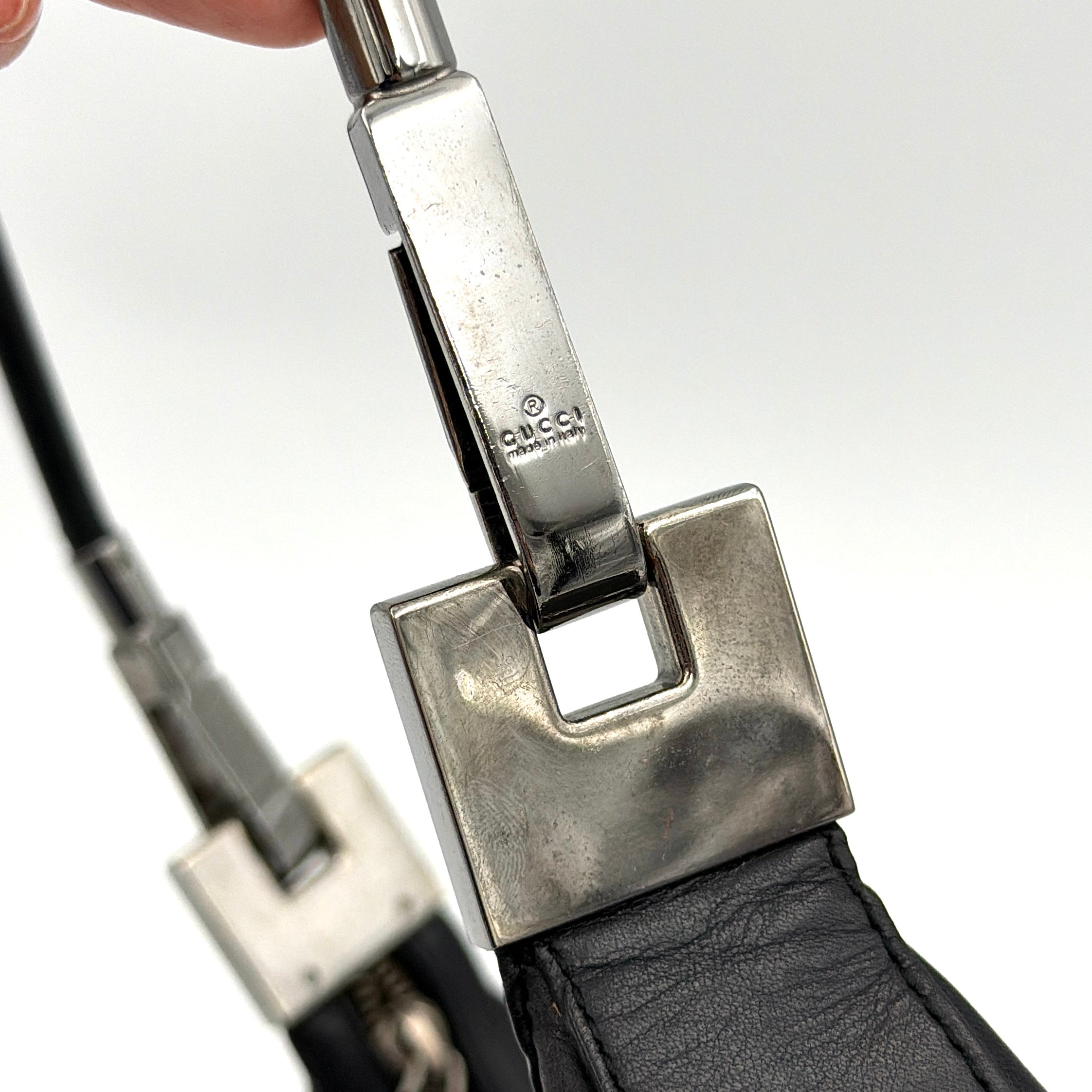 Gucci GG Leather Hobo Shoulder Bag in black smooth leather with sculptural silver-tone hardware and signature GG zip pull.