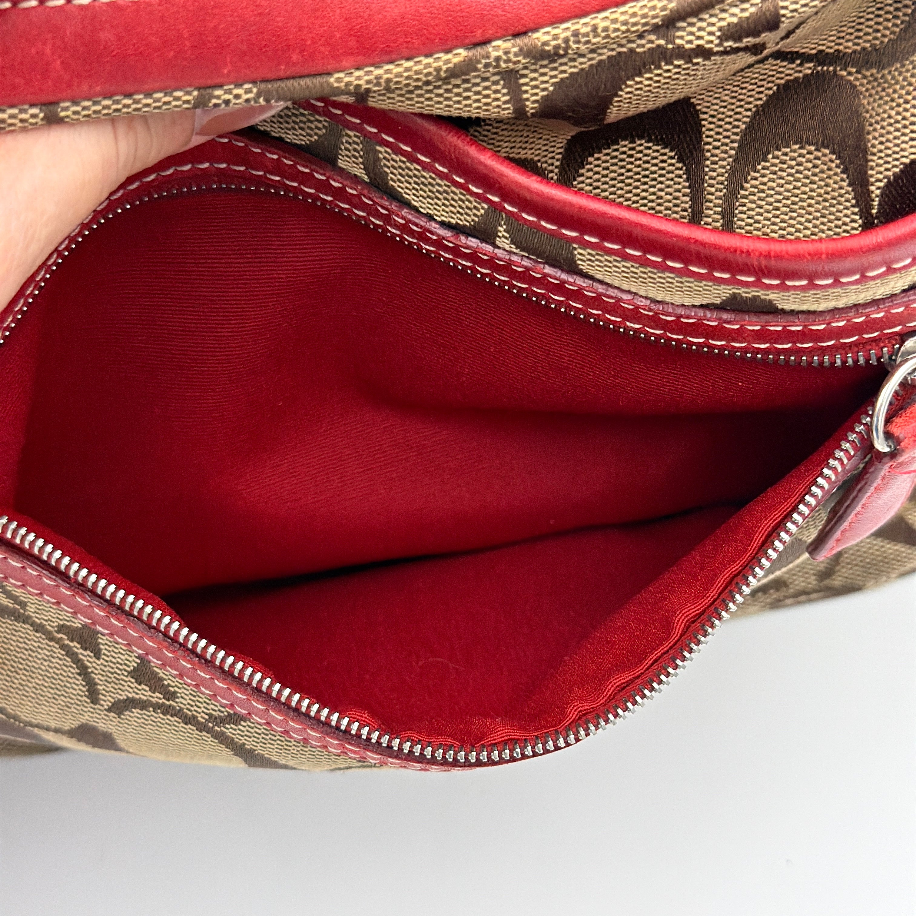 Coach Signature Hamilton Hobo Shoulder Bag in beige monogram canvas with striking red leather trim and a wide hobo silhouette.