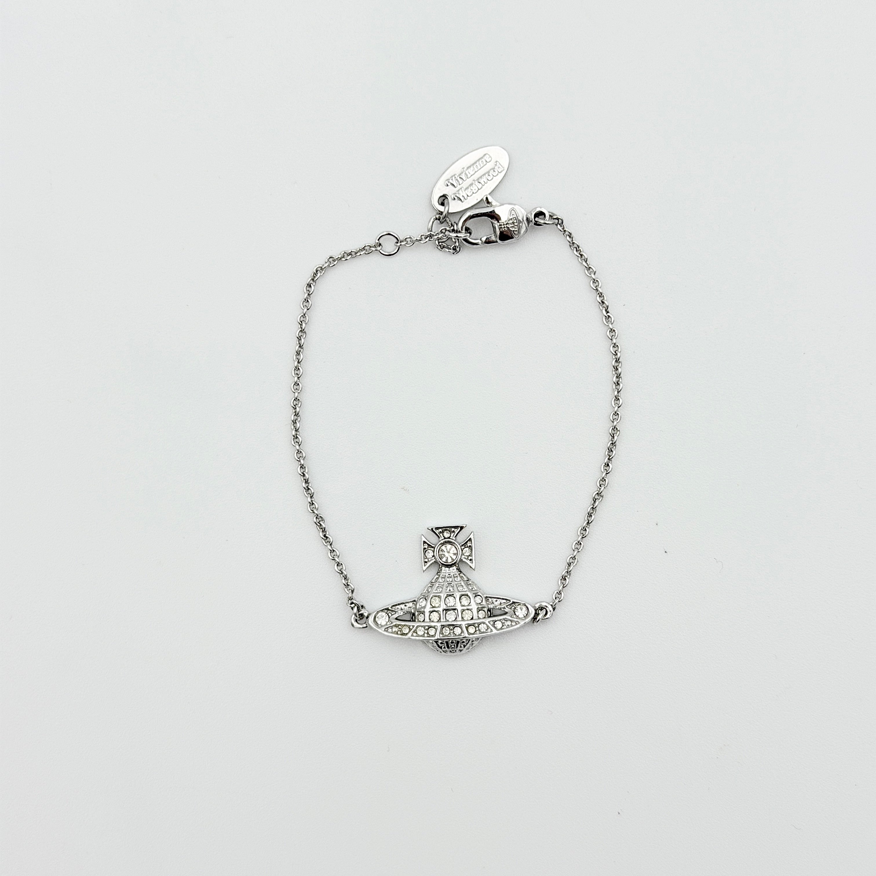Vivienne Westwood silver rhinestone Orb bracelet with delicate chain and branded tag, shown against a clean background.