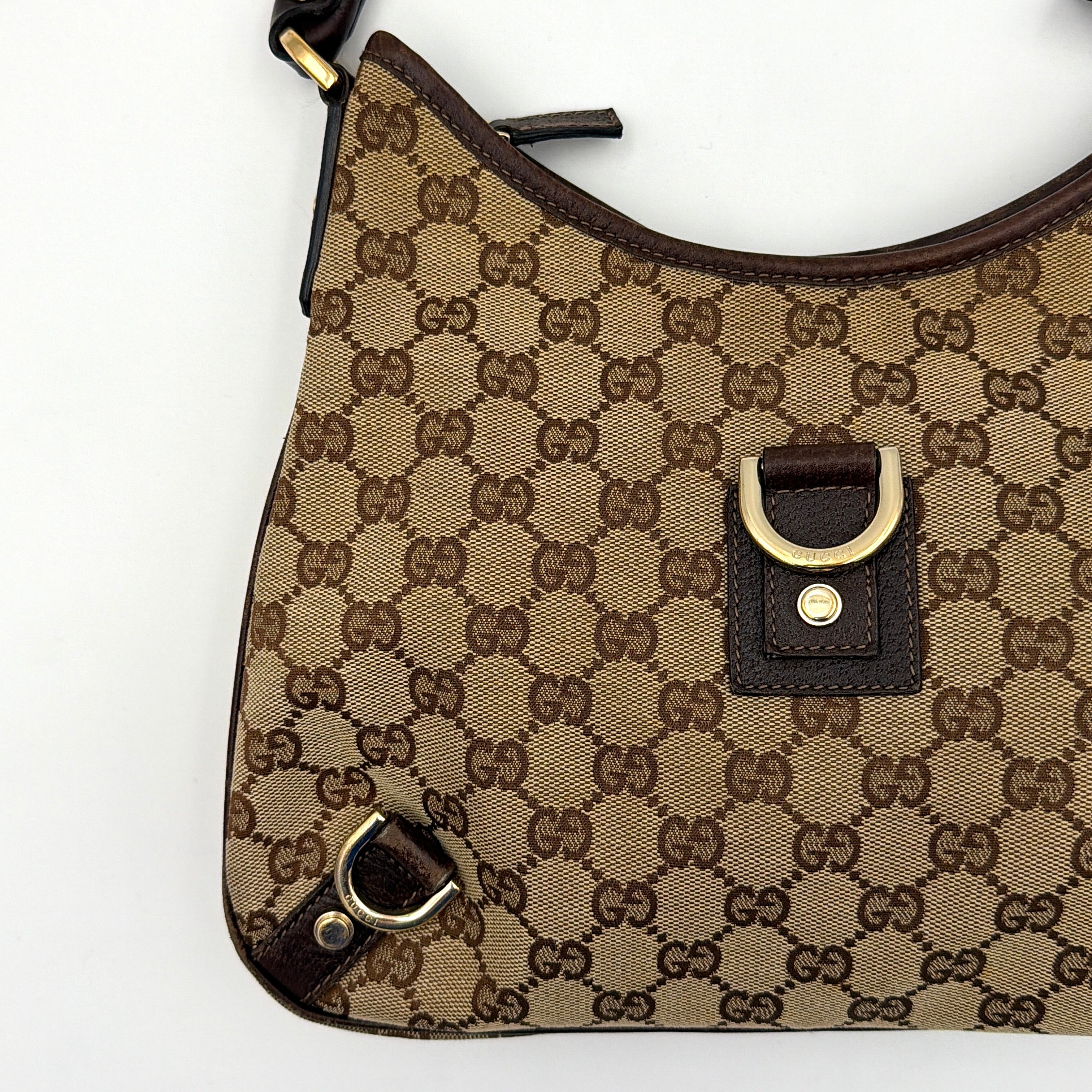Front view of the Gucci GG Monogram Jacquard Abbey Hobo Bag in beige and brown canvas with gold-tone hardware and dark brown leather trim.